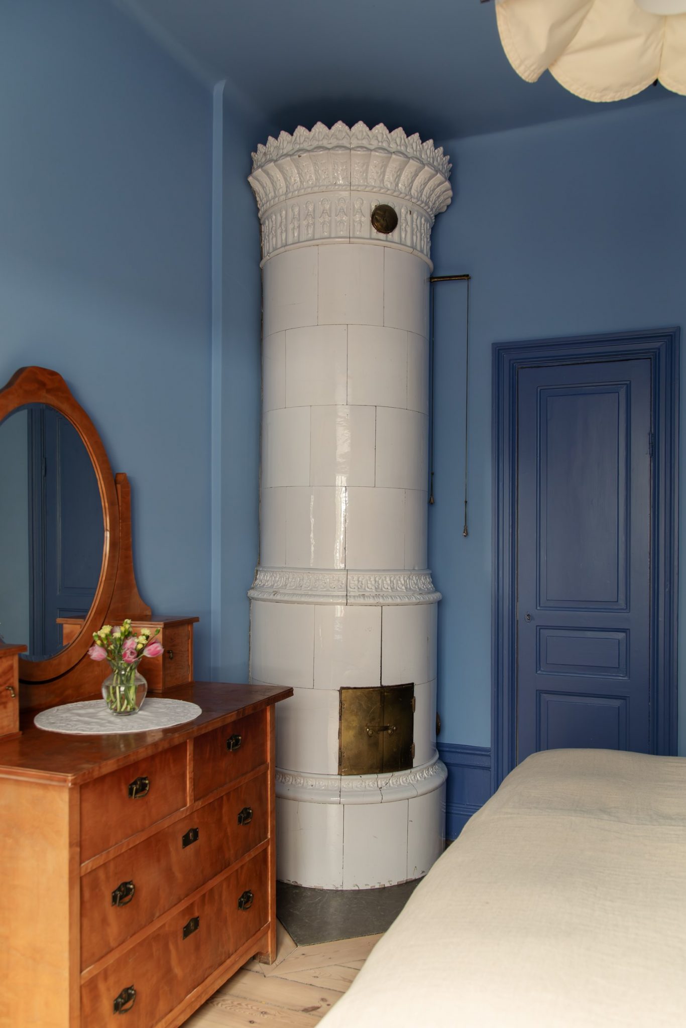 chambre murs bleus avec poêle ancien décoration scandinave appartement deux-pièces 48m2 style vintage dans immeuble du 19e siècle