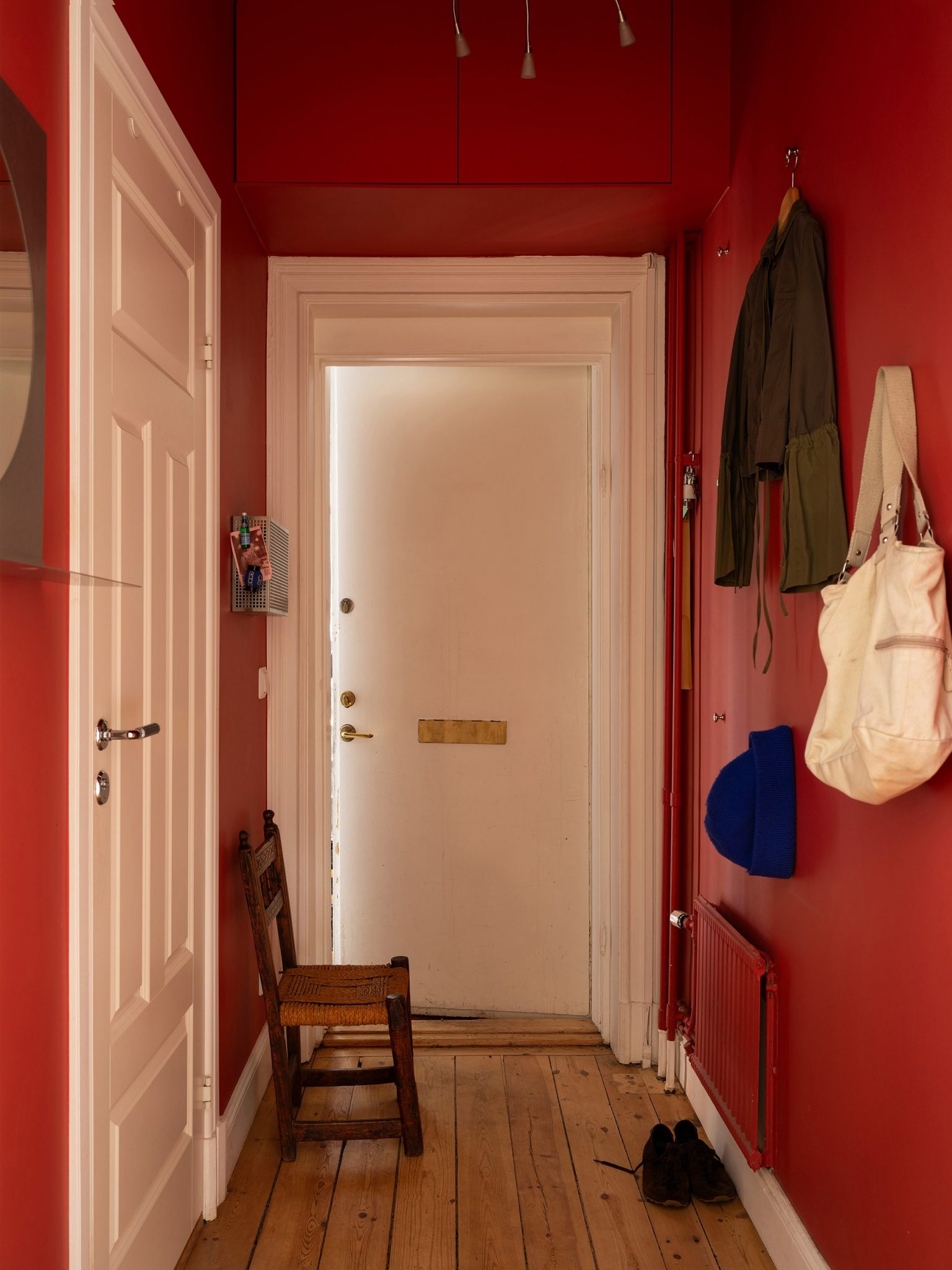 entrée murs rouges décoration scandinave appartement deux-pièces 48m2 style vintage dans immeuble du 19e siècle