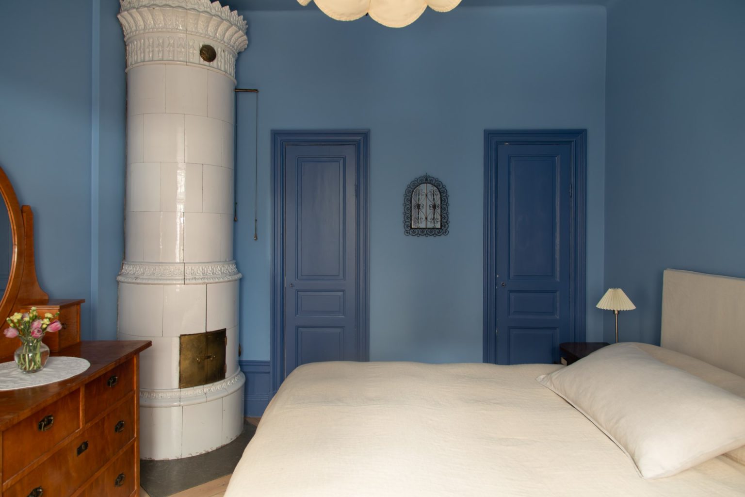chambre murs bleus avec poêle ancien décoration scandinave appartement deux-pièces 48m2 style vintage dans immeuble du 19e siècle
