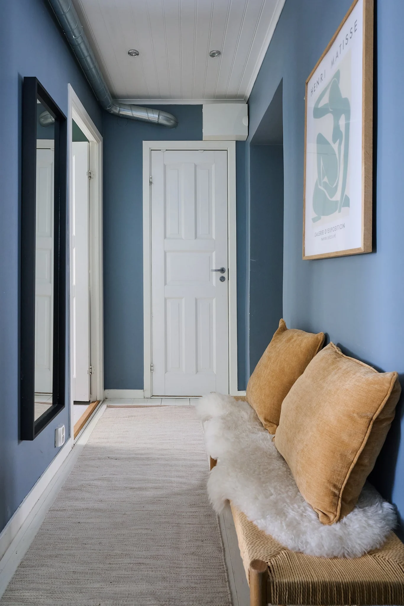 entrée murs bleus avec banc et porte-manteaux décoration scandinave