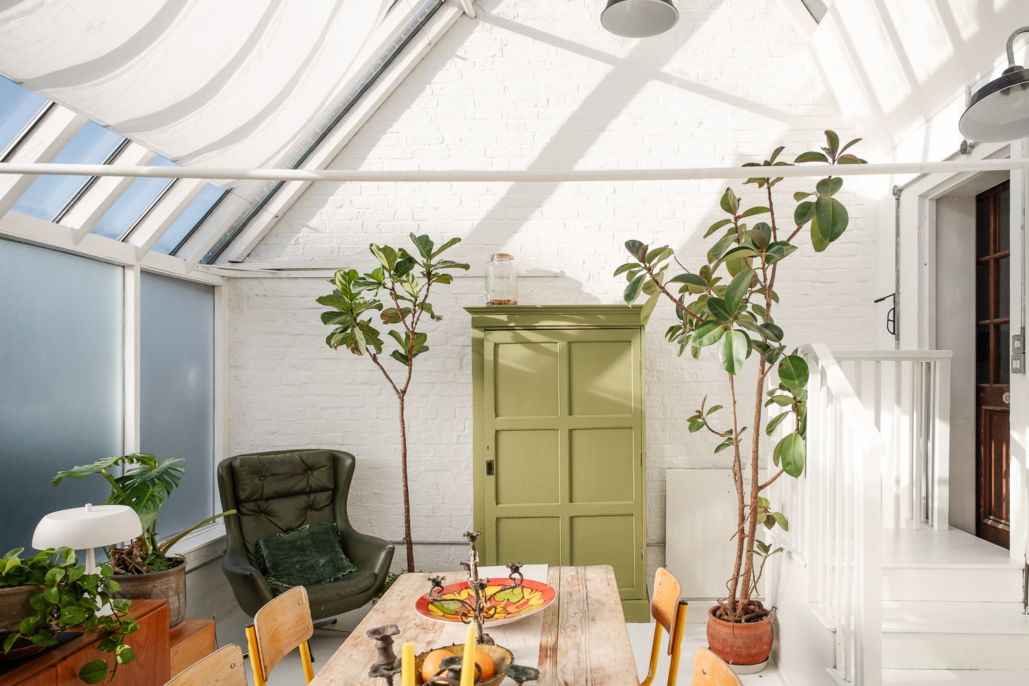 salle à manger décoration vintage double hauteur avec fenêtres zénithales style serre 