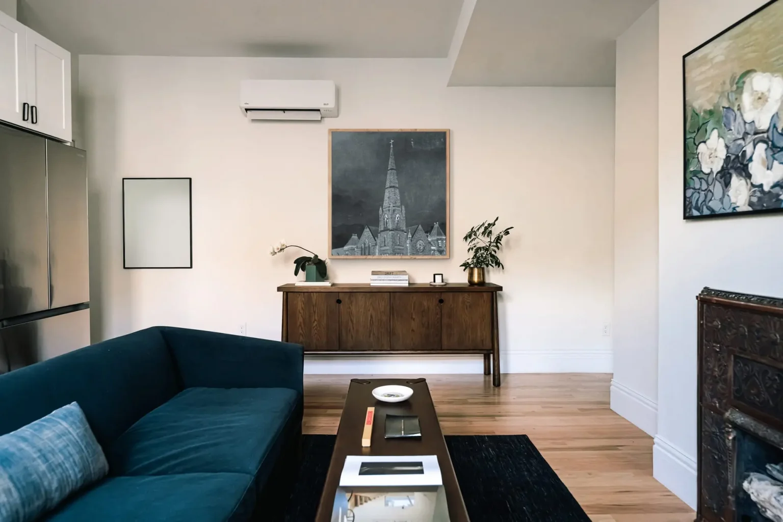 salon avec cheminée ancienne en cuivre et cuisine ouverte décoration classique chic