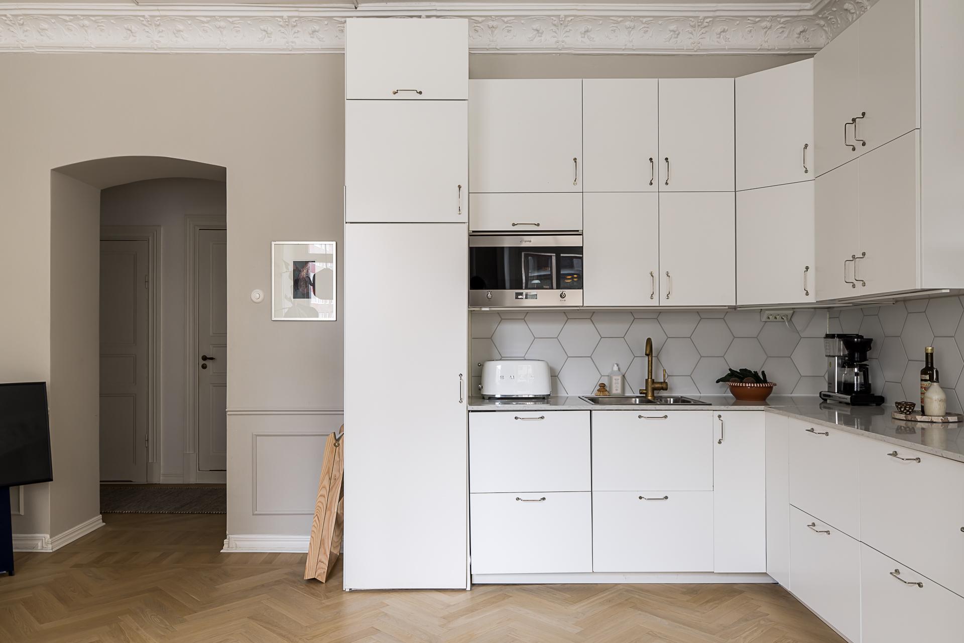 cuisine ouverte sur salon avec moulures décoration scandinave contemporaine dans immeuble Art Nouveau