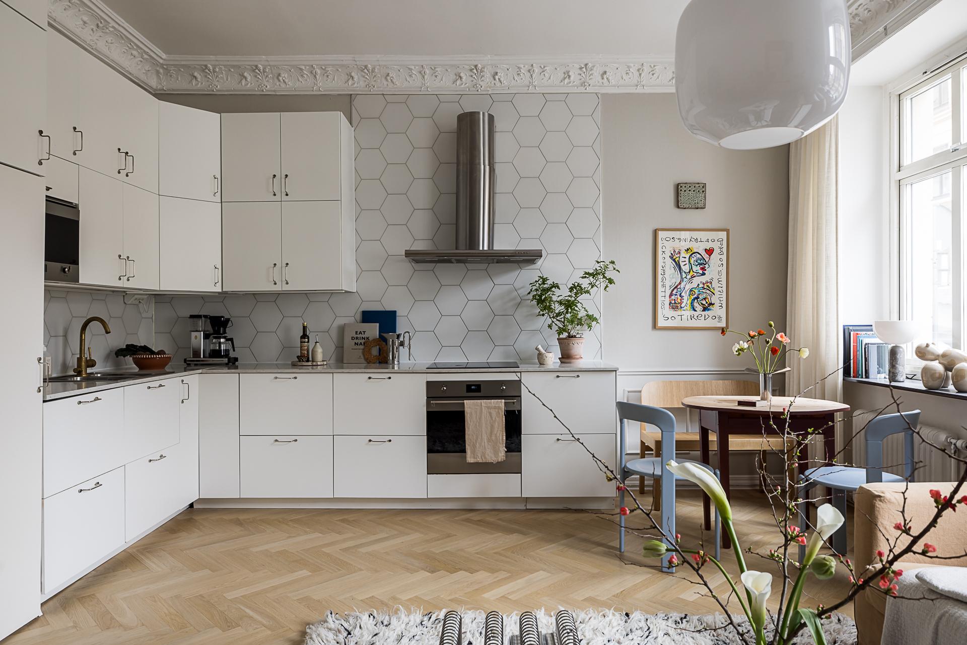 cuisine ouverte et salon avec moulures décoration scandinave contemporaine dans immeuble Art Nouveau