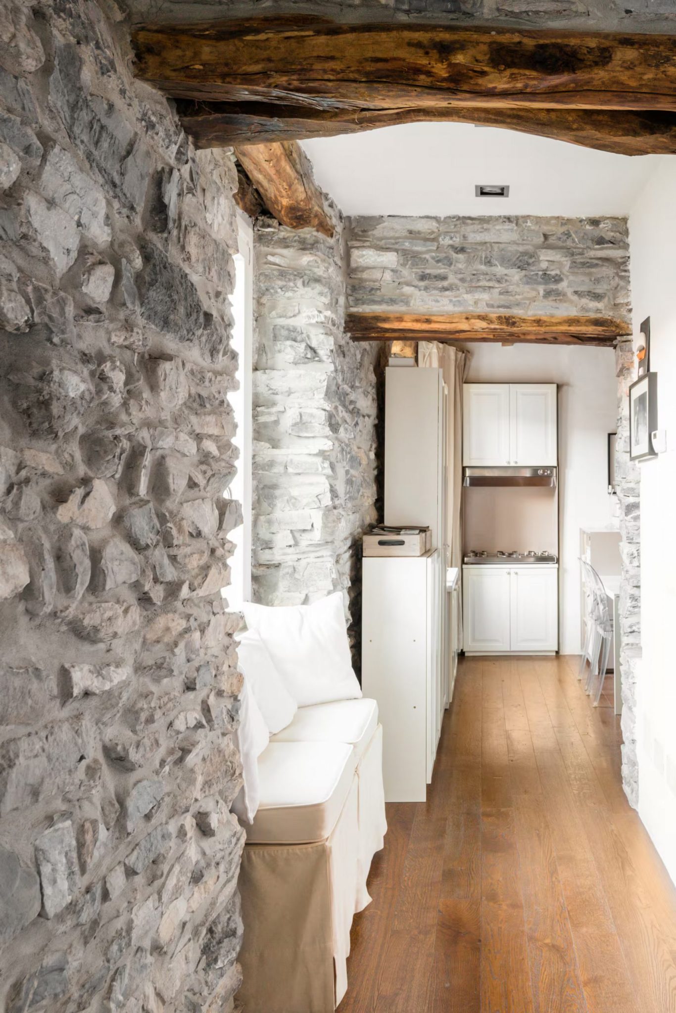 couloir avec poutres anciennes murs pierre grise appartement décoration rustique chic vue lac de Côme