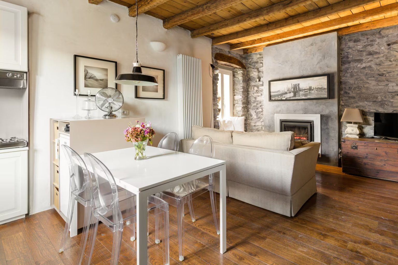 salle à manger et salon avec cheminée murs pierre grise appartement décoration rustique chic vue lac de Côme