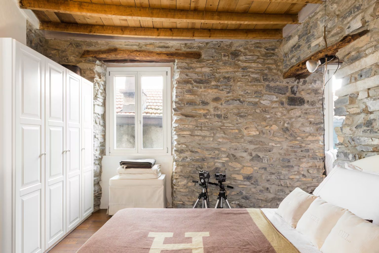 chambre avec poutres murs pierre grise appartement décoration rustique chic vue lac de Côme