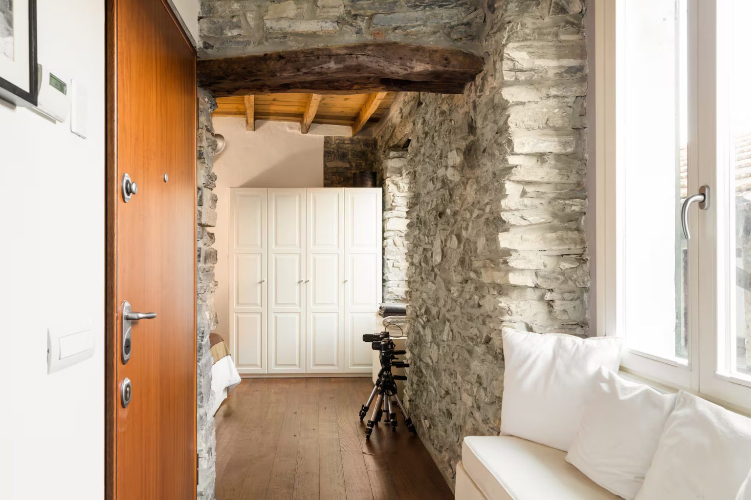 entrée avec poutres anciennes murs pierre grise appartement décoration rustique chic vue lac de Côme