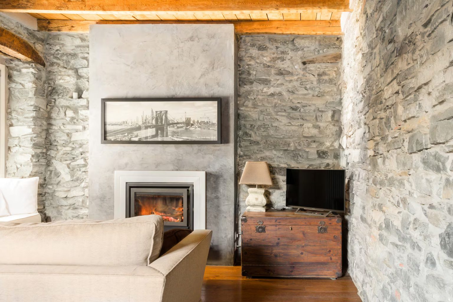 salon avec cheminée murs pierre grise appartement décoration rustique chic vue lac de Côme