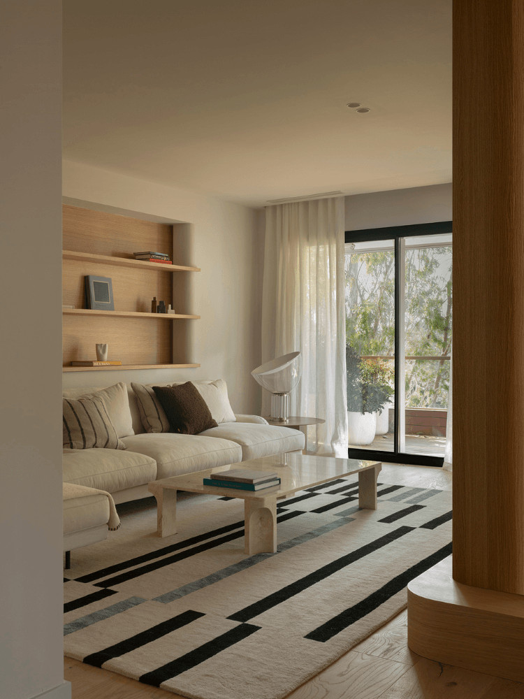 Living room with double-sided fireplace and french windows, contemporary beige decor