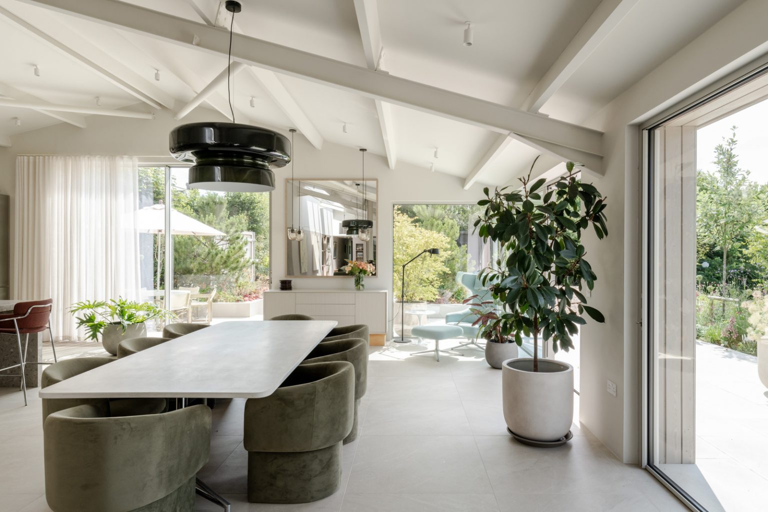 salle à manger maison contemporaine durable avec grandes baies vitrées et jardin paysagé