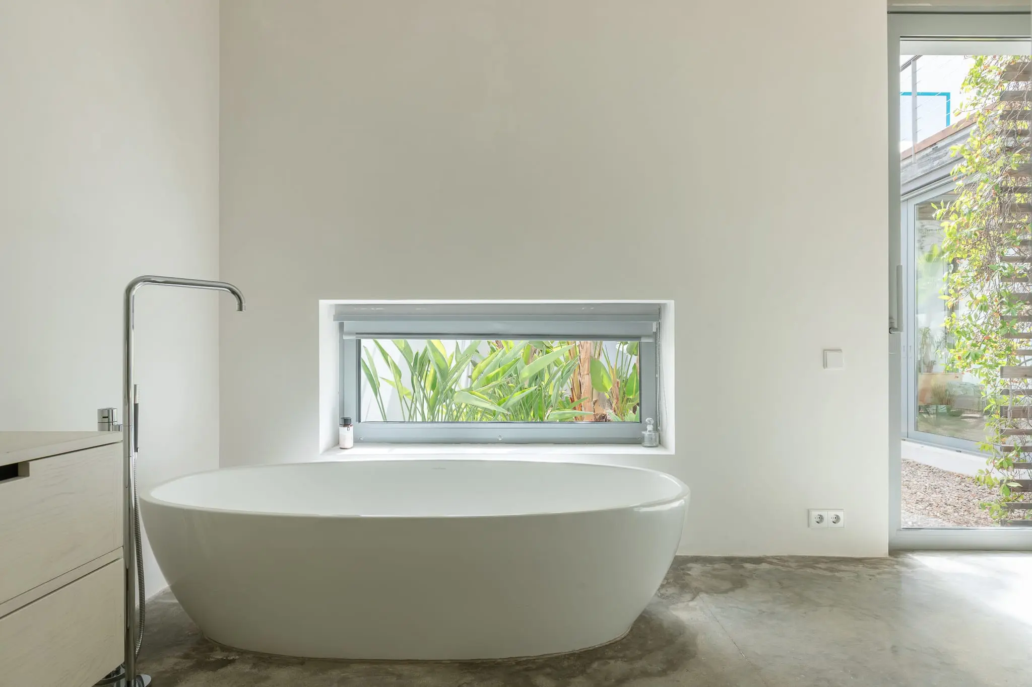 salle de bain avec baignoire îlot design sol béton