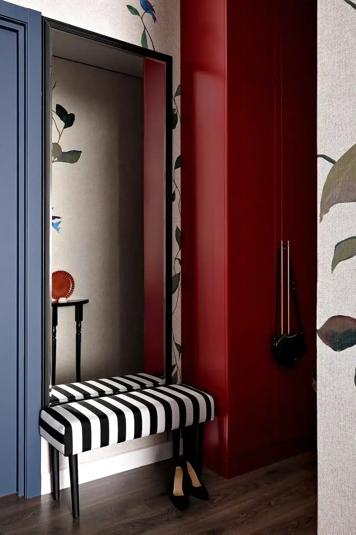entrée banc rayé placard rouge appartement de 45m2 décoration maximaliste et colorée