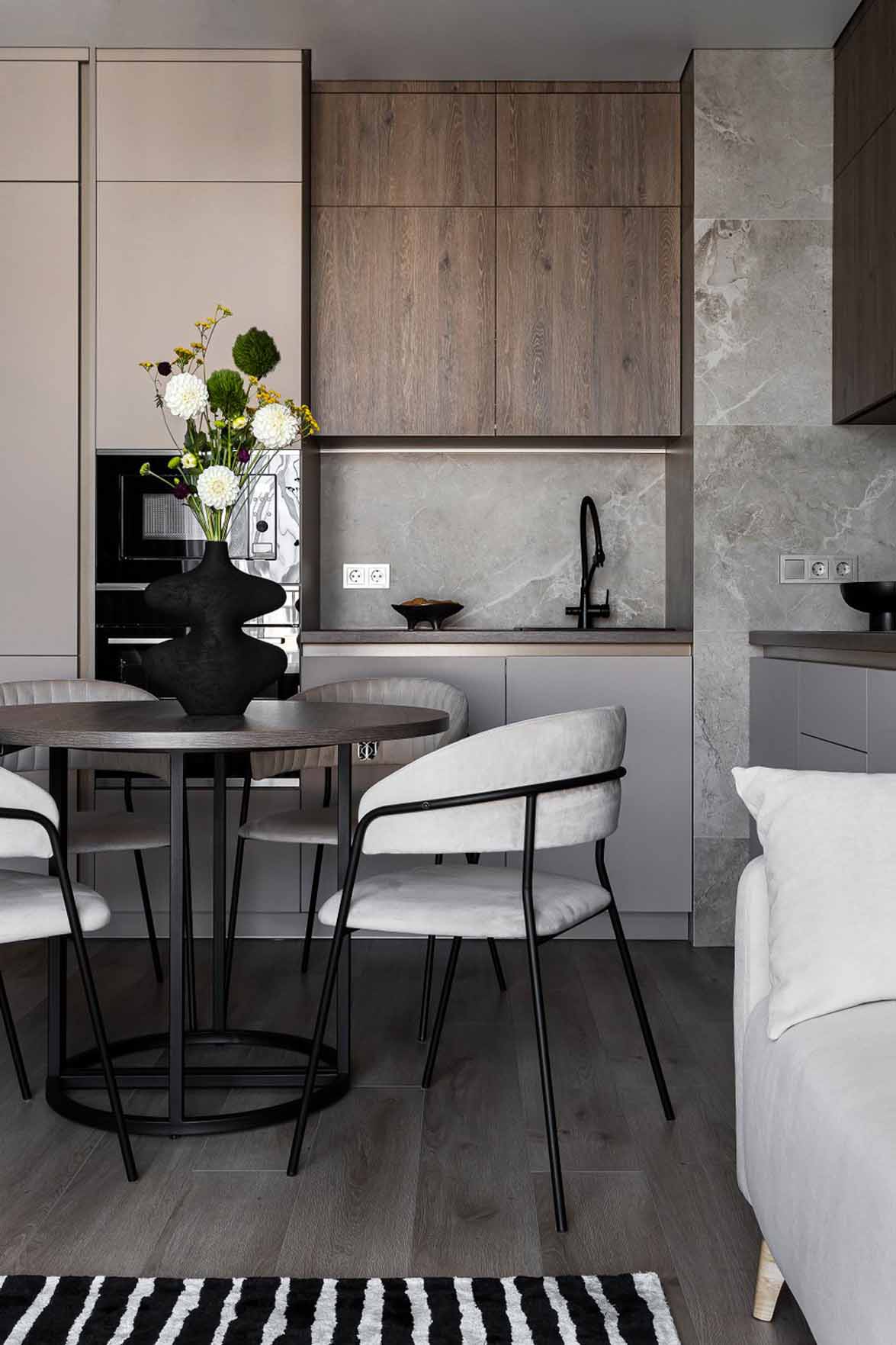 Open kitchen and living room with white sofa and black and white rug, 60m2 neutral flat Open kitchen and living room with white sofa and black and white rug, 60m2 neutral flat