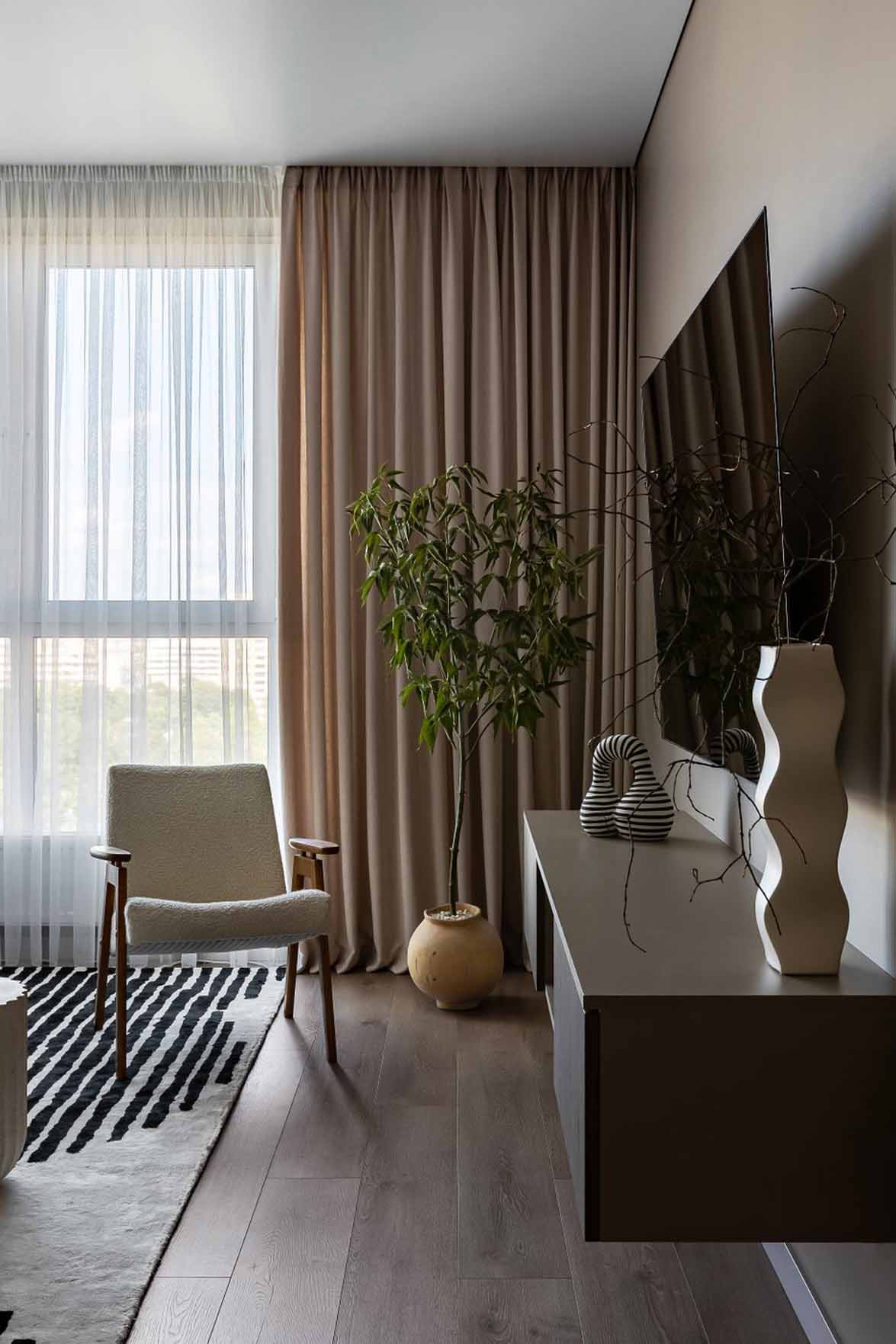 Living room with white armchaire and black and white rug, 60m2 neutral flat Living room with white armchaire and black and white rug, 60m2 neutral flat