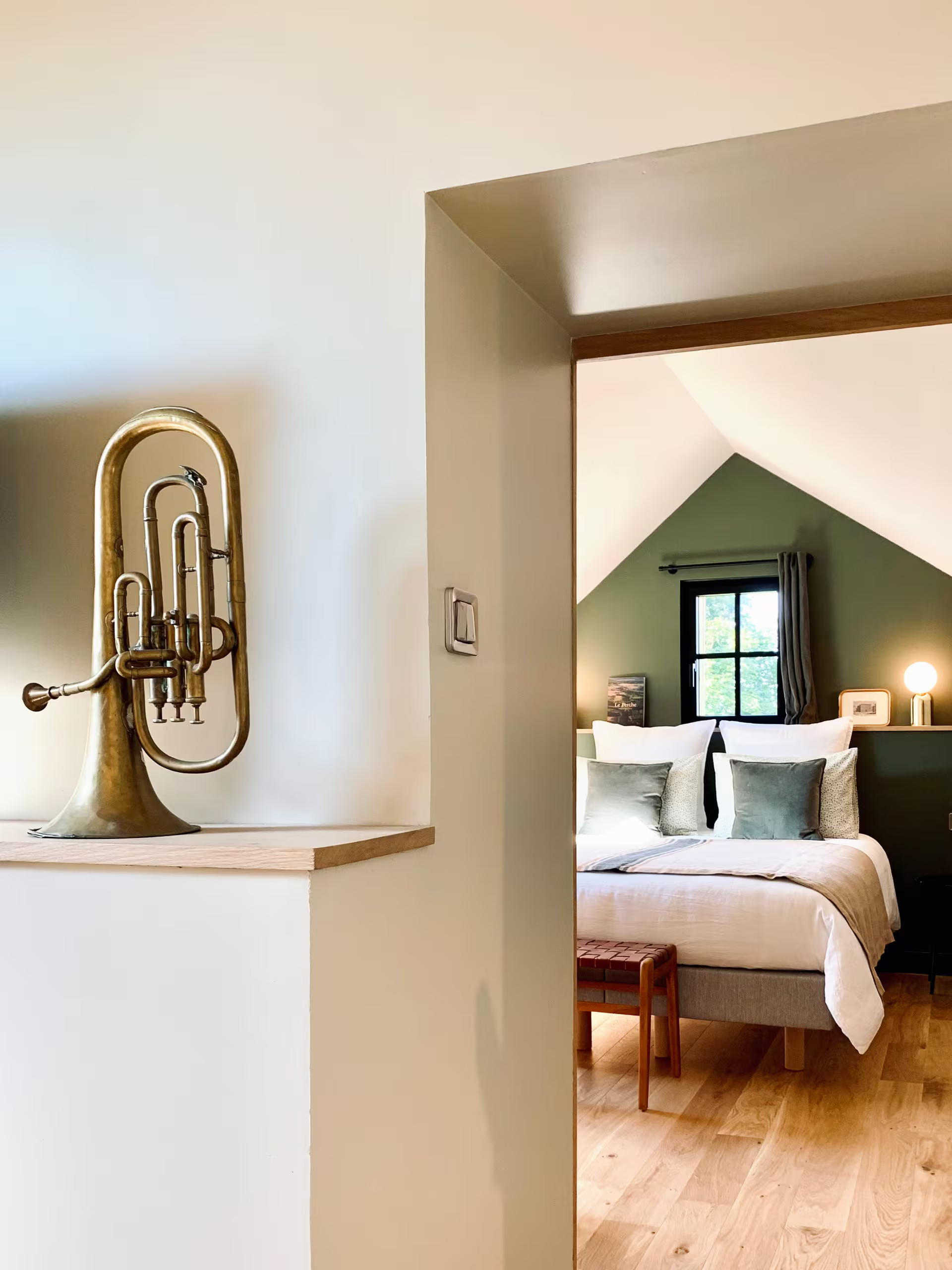 attic bedrom with beams and green wall La Clef des Champs
