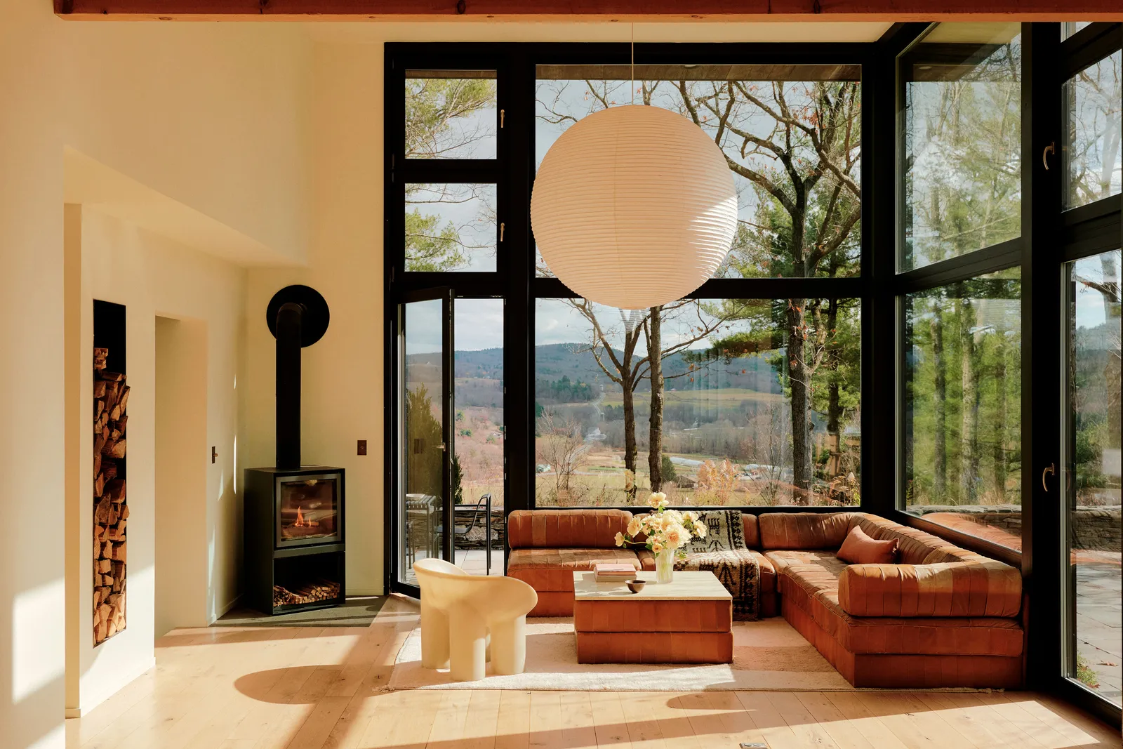 Contemporary living room decor with wood-burning stove and bay windows in a wooden house in the Hudson Valley Contemporary living room decor with wood-burning stove and bay windows in a wooden house in the Hudson Valley