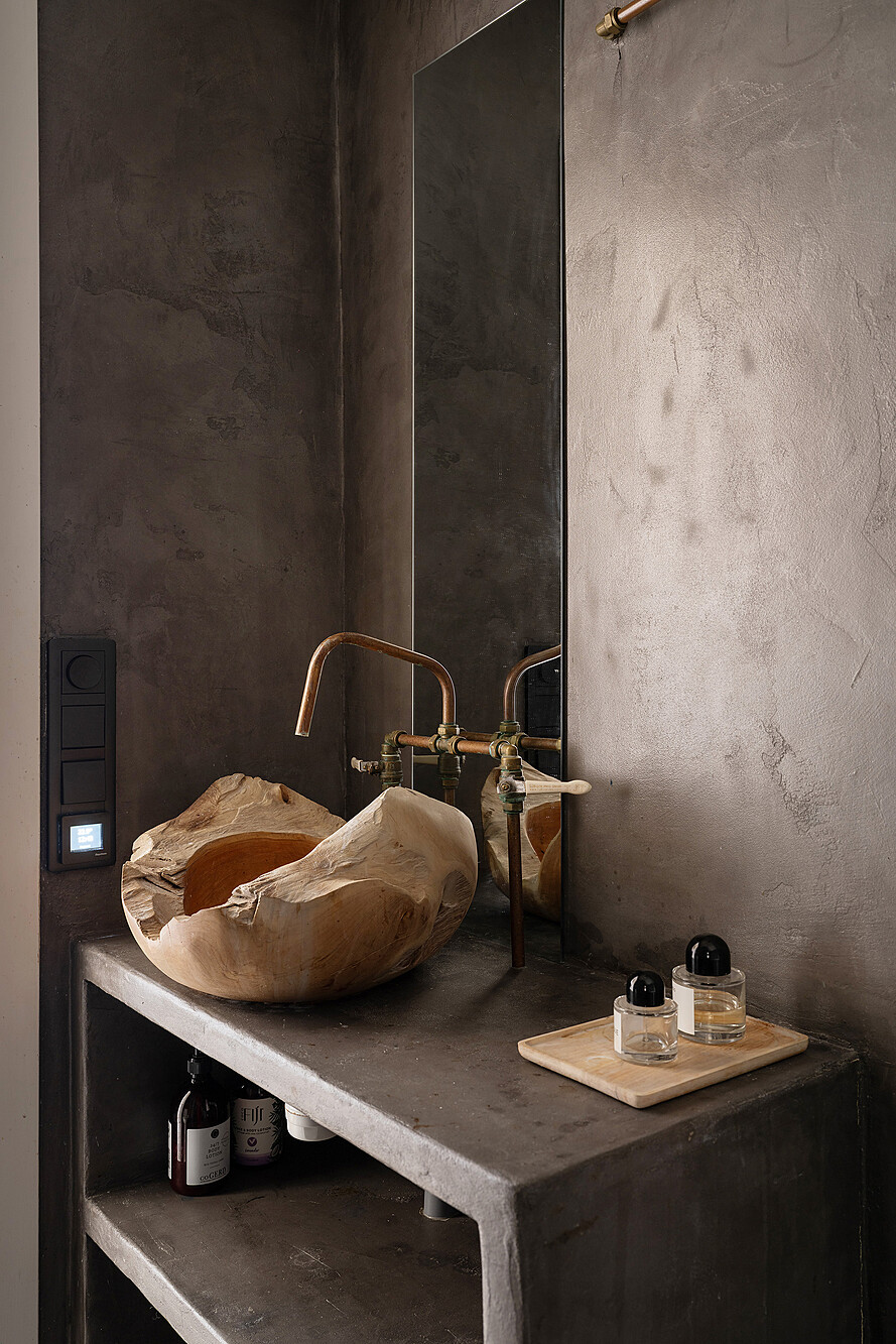 salle de bain murs gris béton éclairée en second jour par fenêtre intérieure sur chambre appartement deux-pièces ancien décoration vintage et bohème