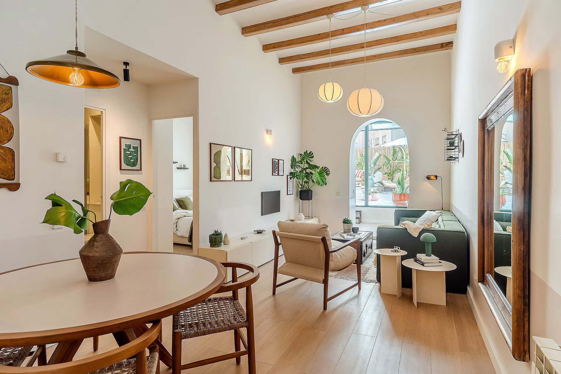 dining and living room with beams and green sofa modern apartment in Barcelona