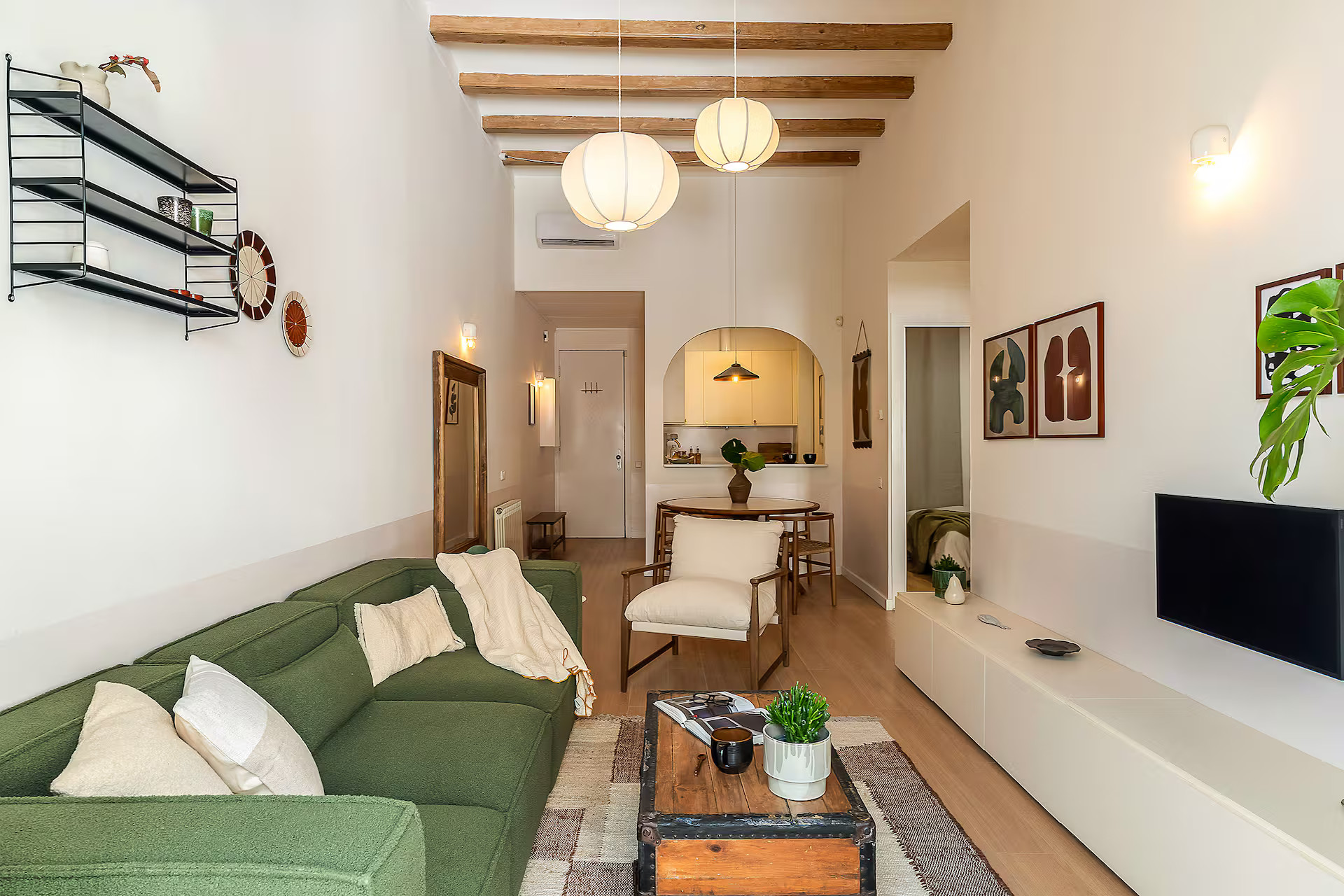 dining and living room with beams and green sofa modern apartment in Barcelona