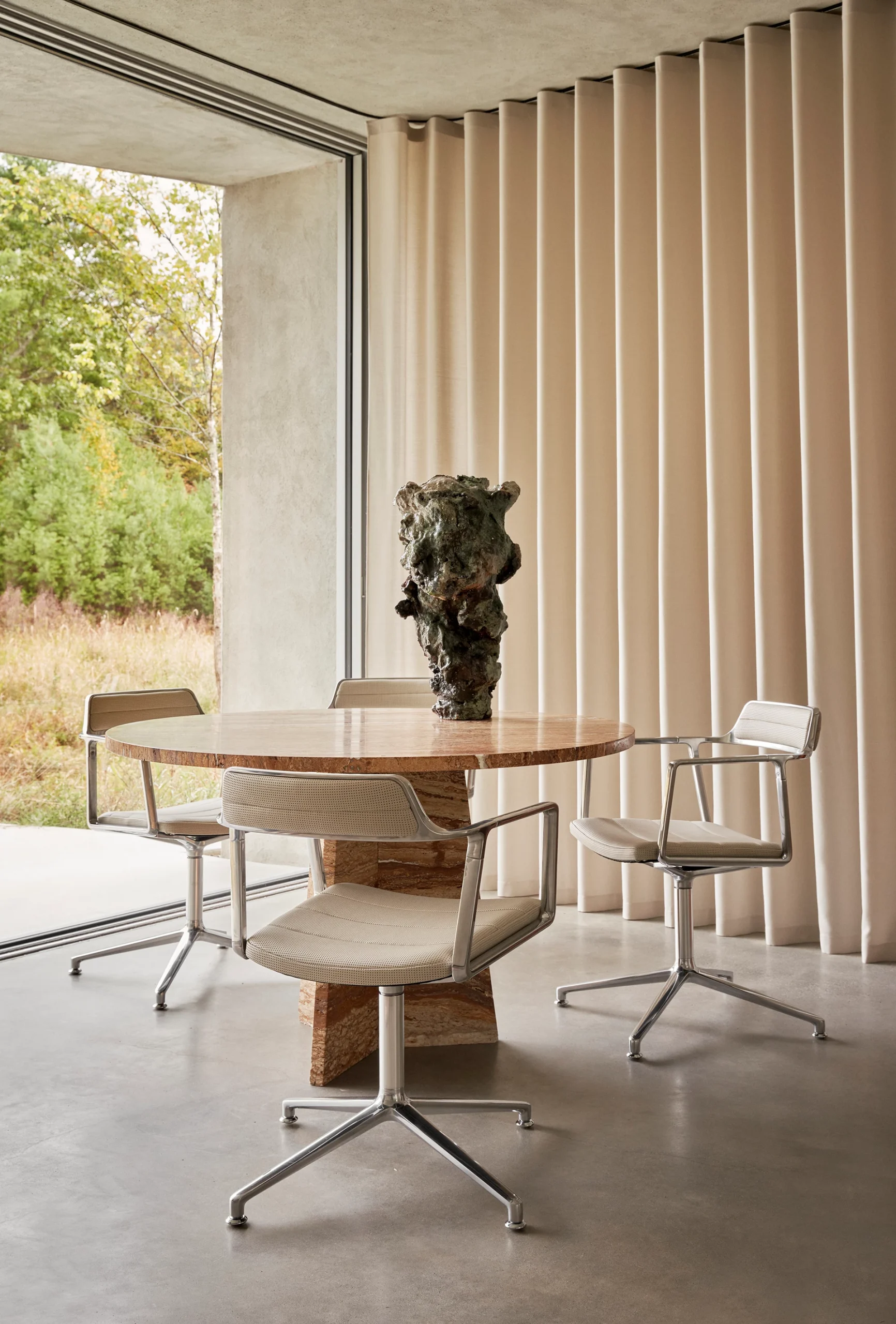 salle à manger design avec table ronde en travertin