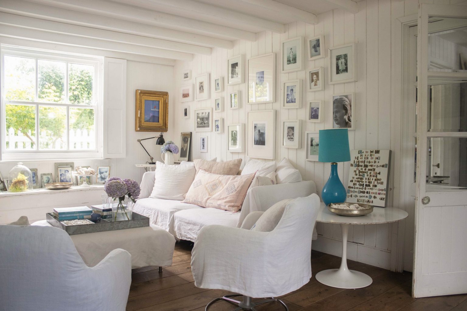 salon avec mur d'images maison anglaise décoration country chic blanche