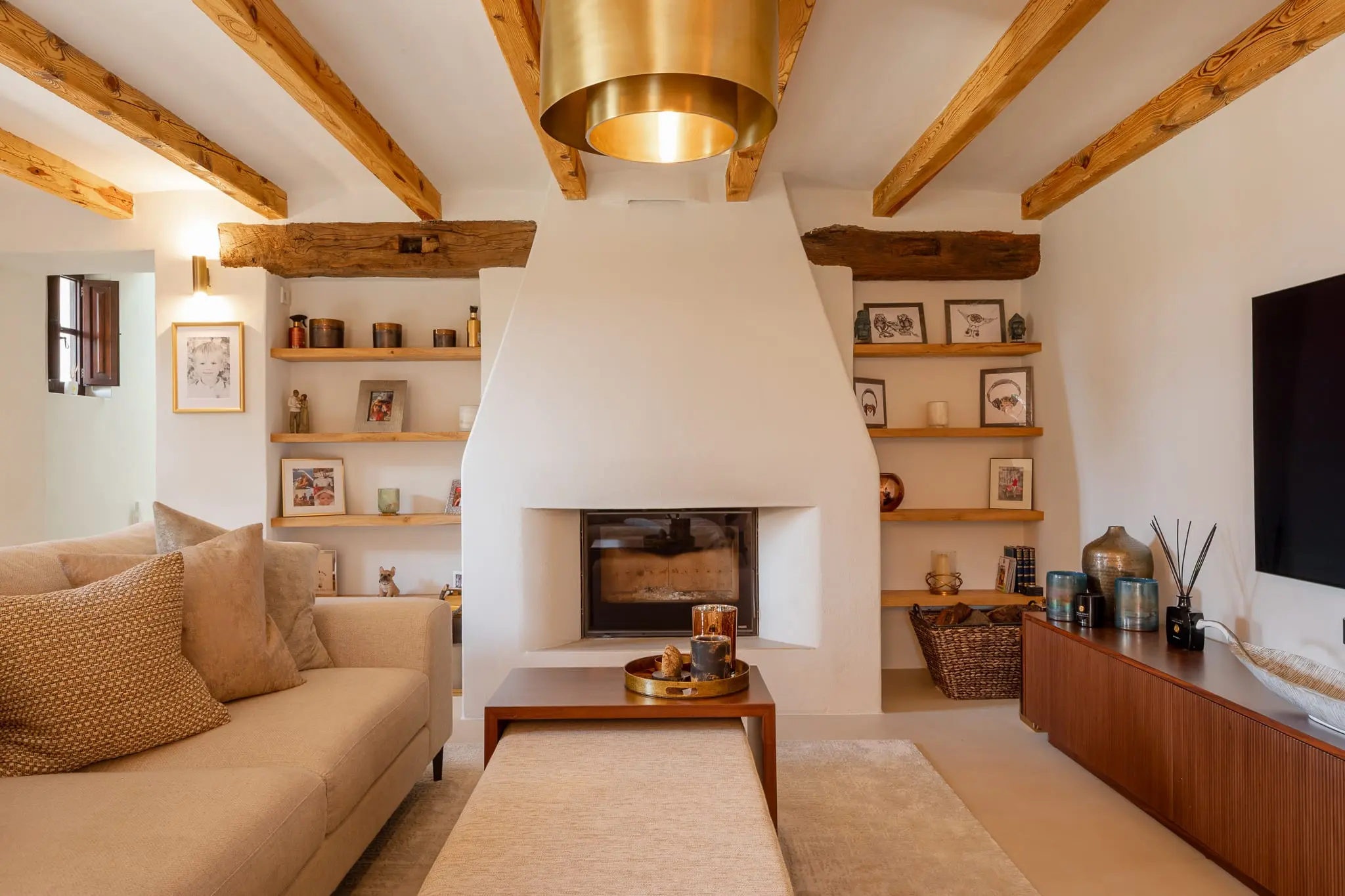 cheminée en plâtre dans salon avec poutres décoration contemporaine finca authentique modernisée à Ibiza avec piscine