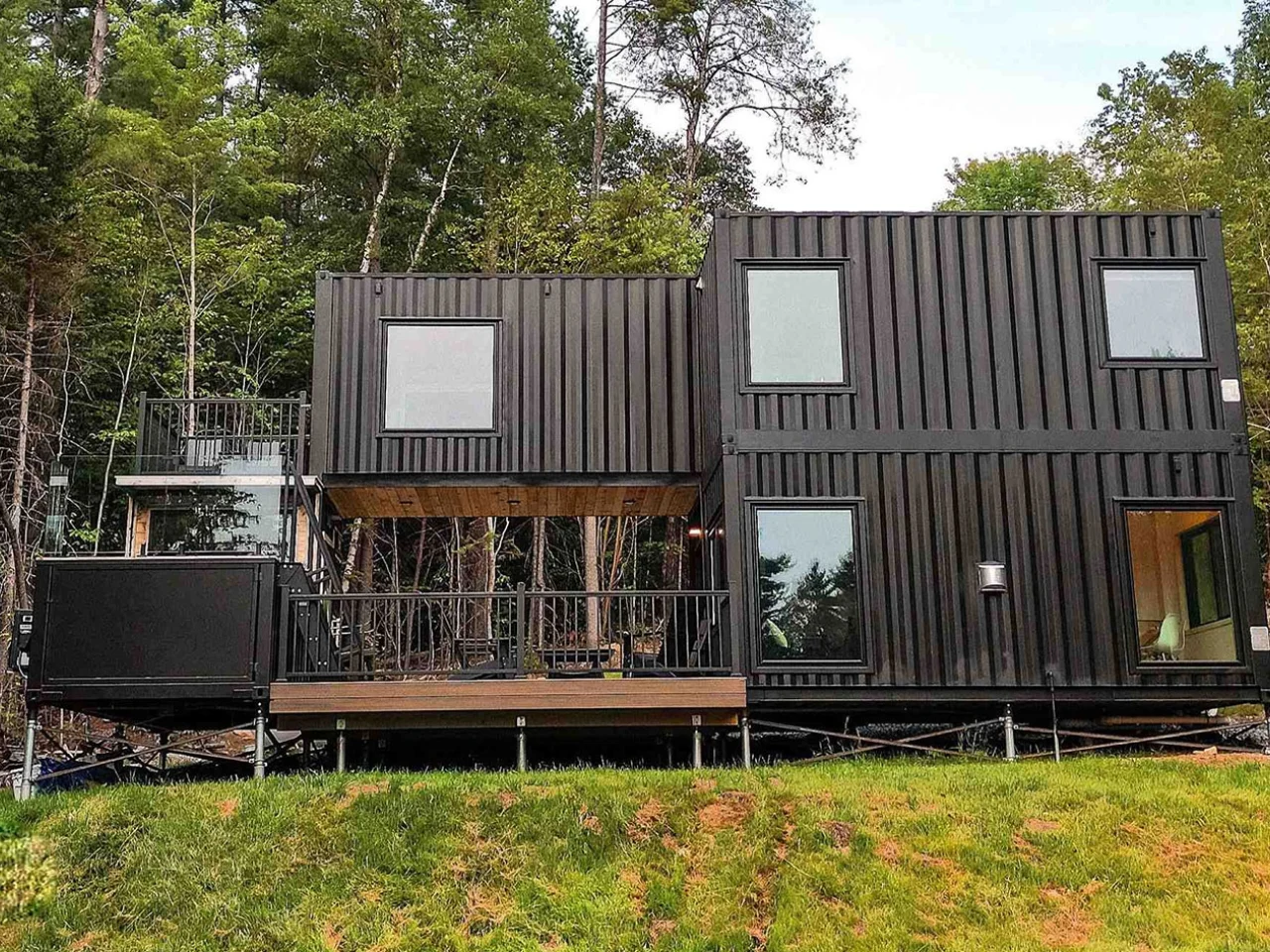 A spacious container home with a pool and sauna surrounded by nature