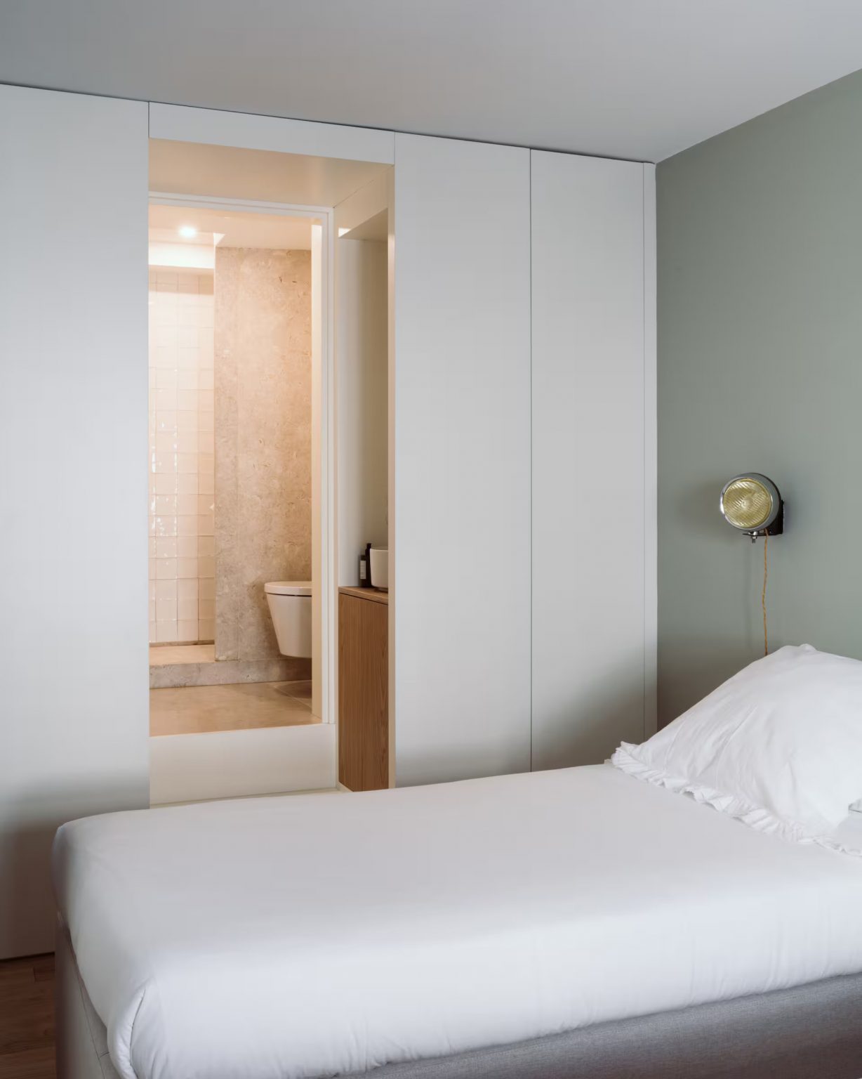 chambre minimaliste verte appartement ancien à Lisbonne avec salle de bain