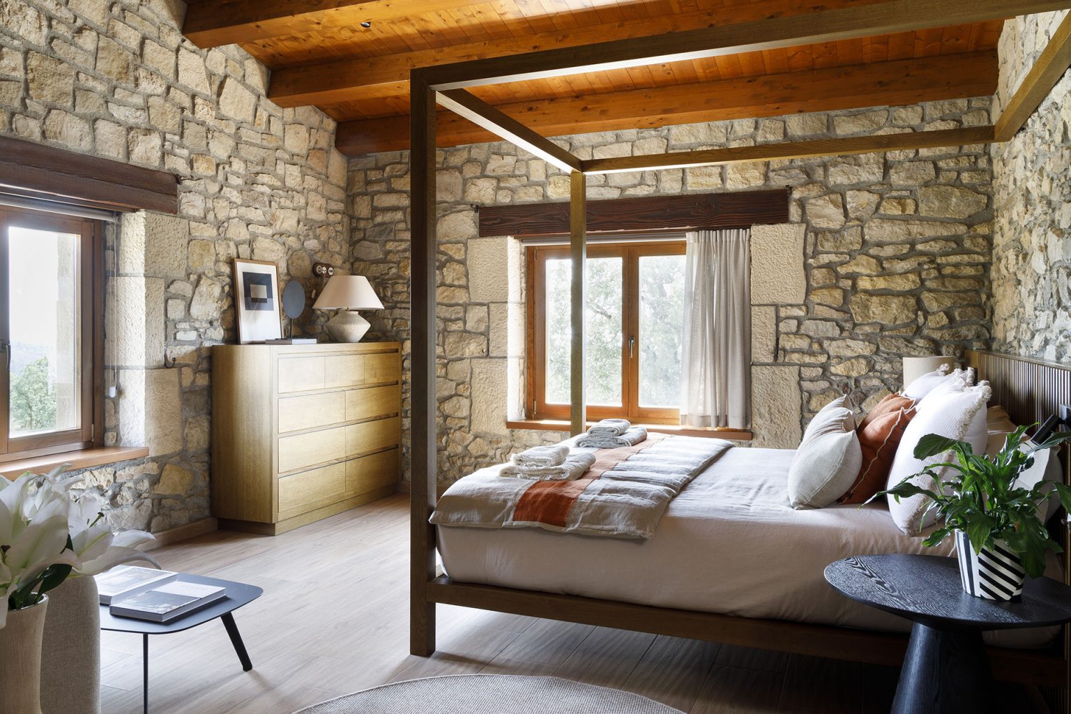 chambre lit baldaquin murs de pierres et poutres décoration contemporaine maison catalane Mas Summit