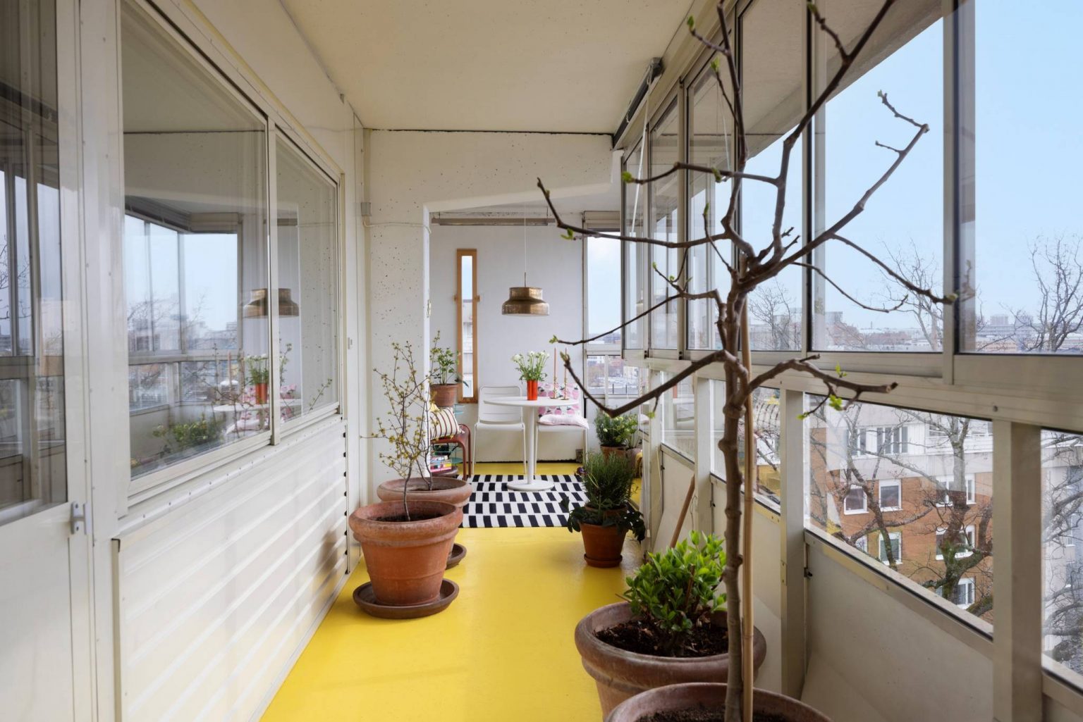 salon dans balcon vitré sol jaune appartement au style sixties décoration colorée
