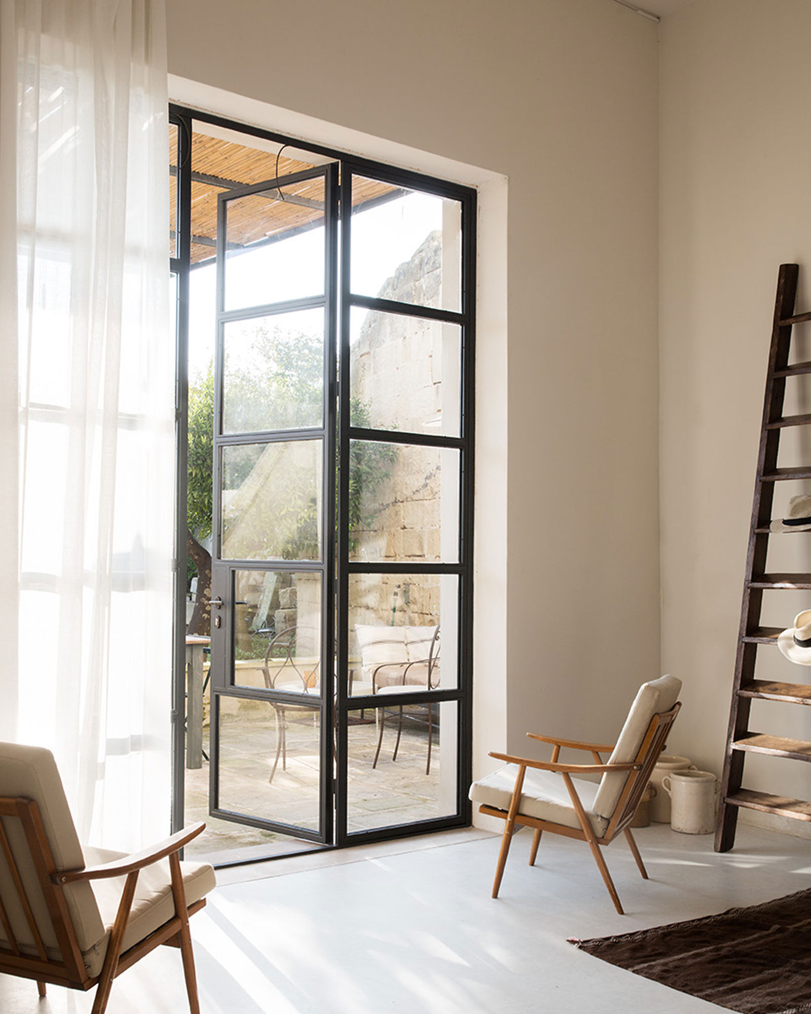 living room with industrial bay window renovated historic townhouse in Puglia modern decor