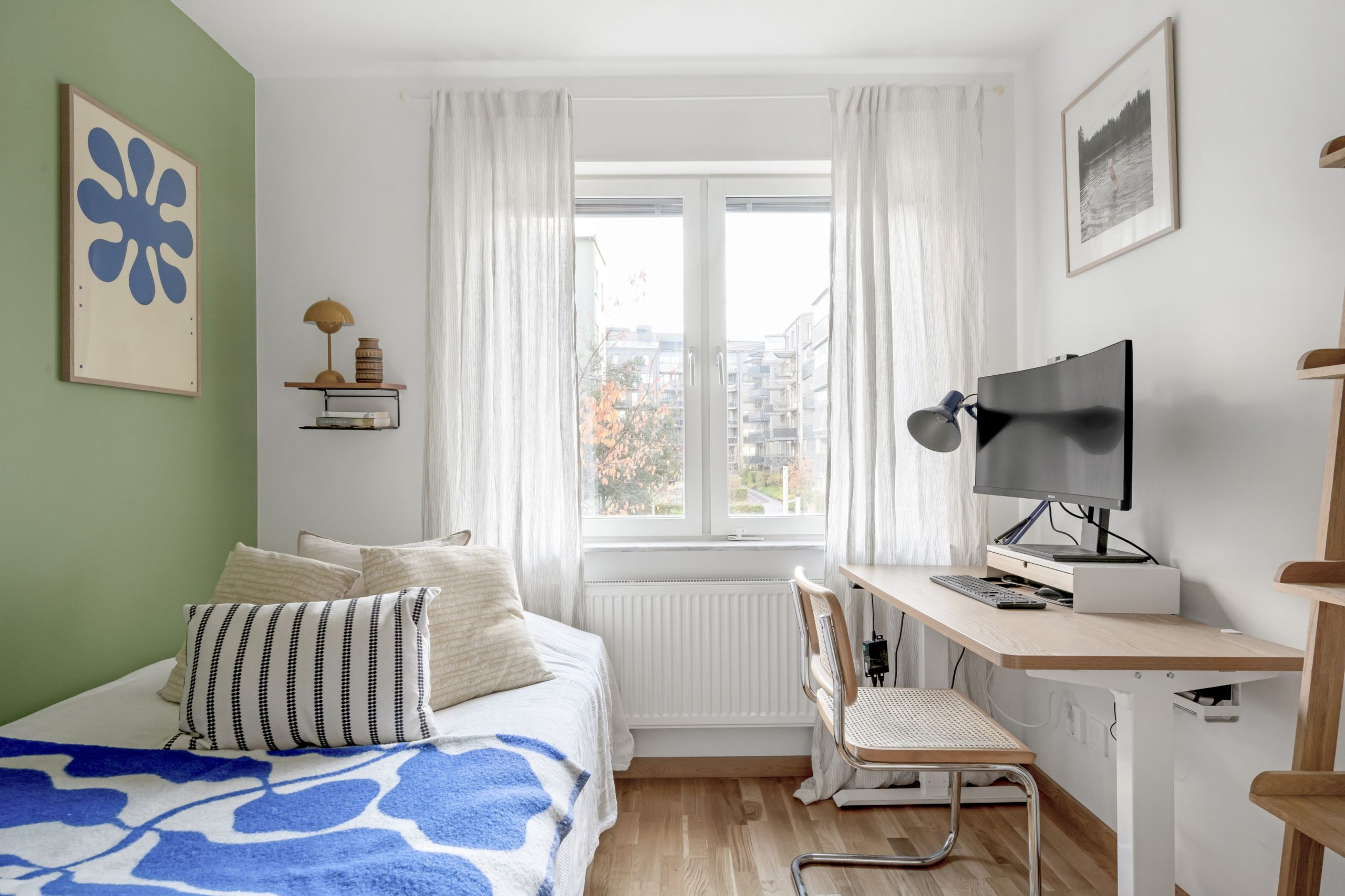 bedroom with an accent green wall and Arket blanket and desk bedroom with an accent green wall and Arket blanket and desk