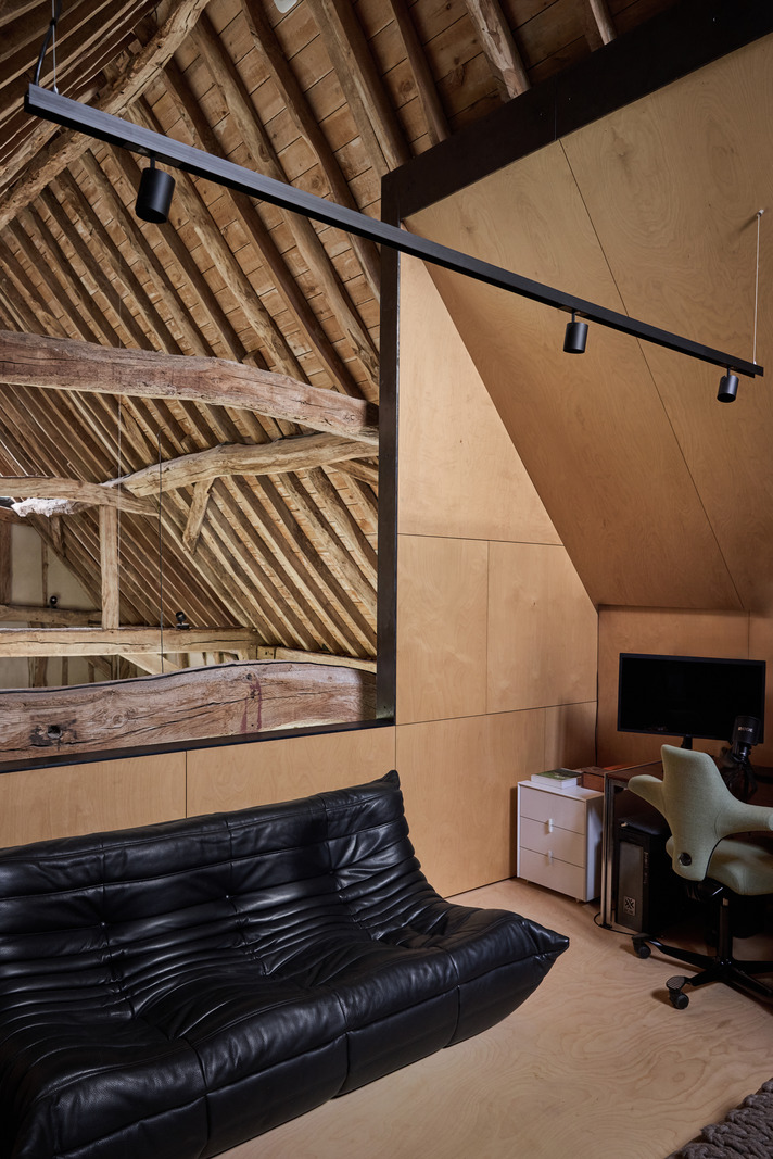 Black leather Togo sofa in home office with beams contemporary decor former English barn renovated