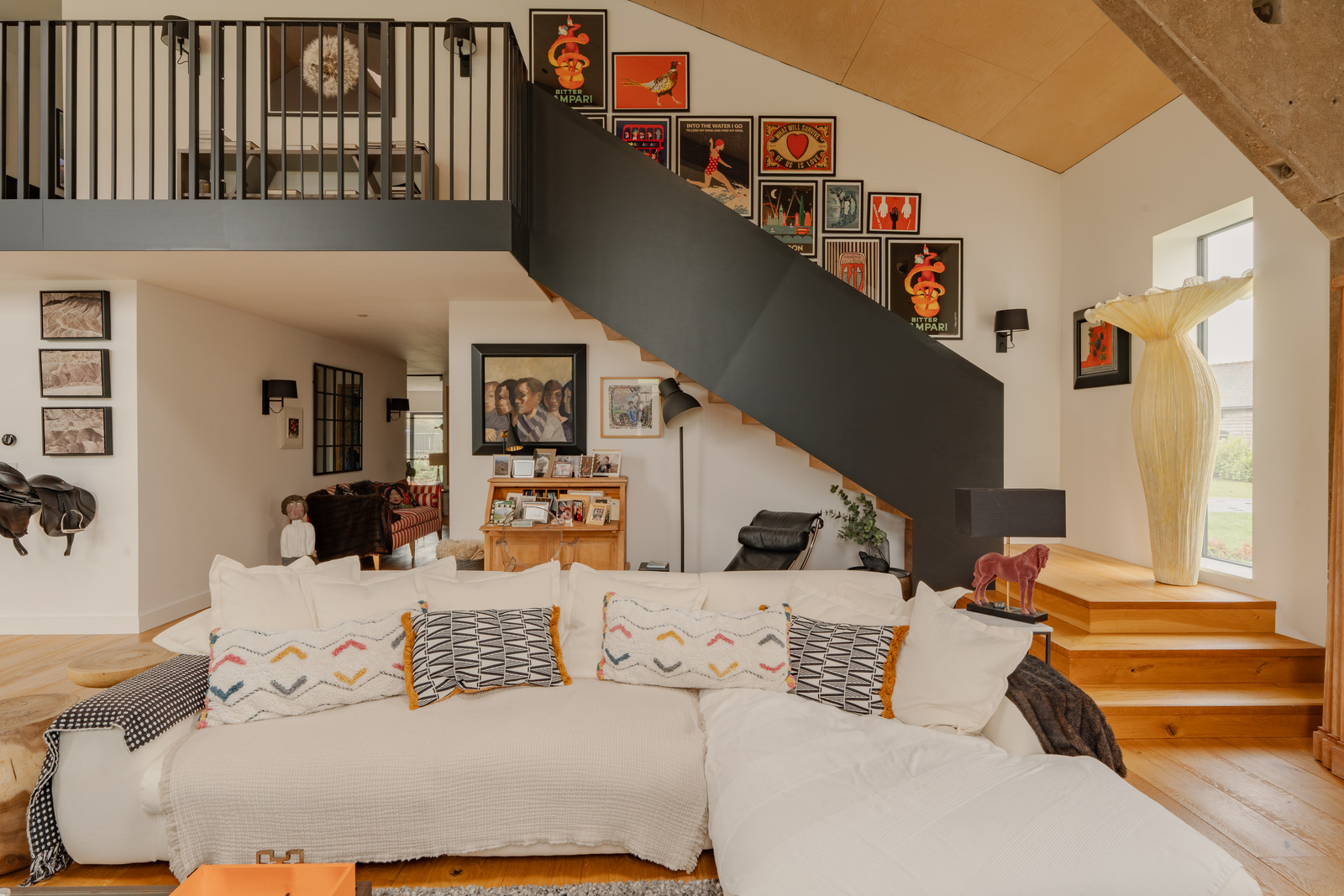 double height living room contemporary decor with mezzanine and black metal staircase