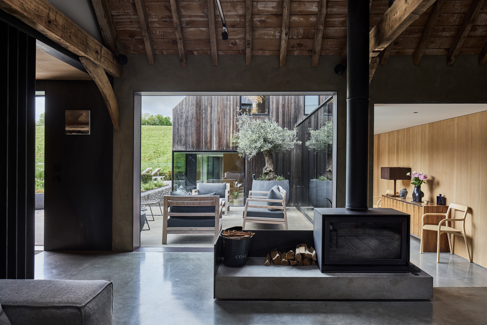 living room with beams and stove contemporary decor former English barn renovated concrete floor