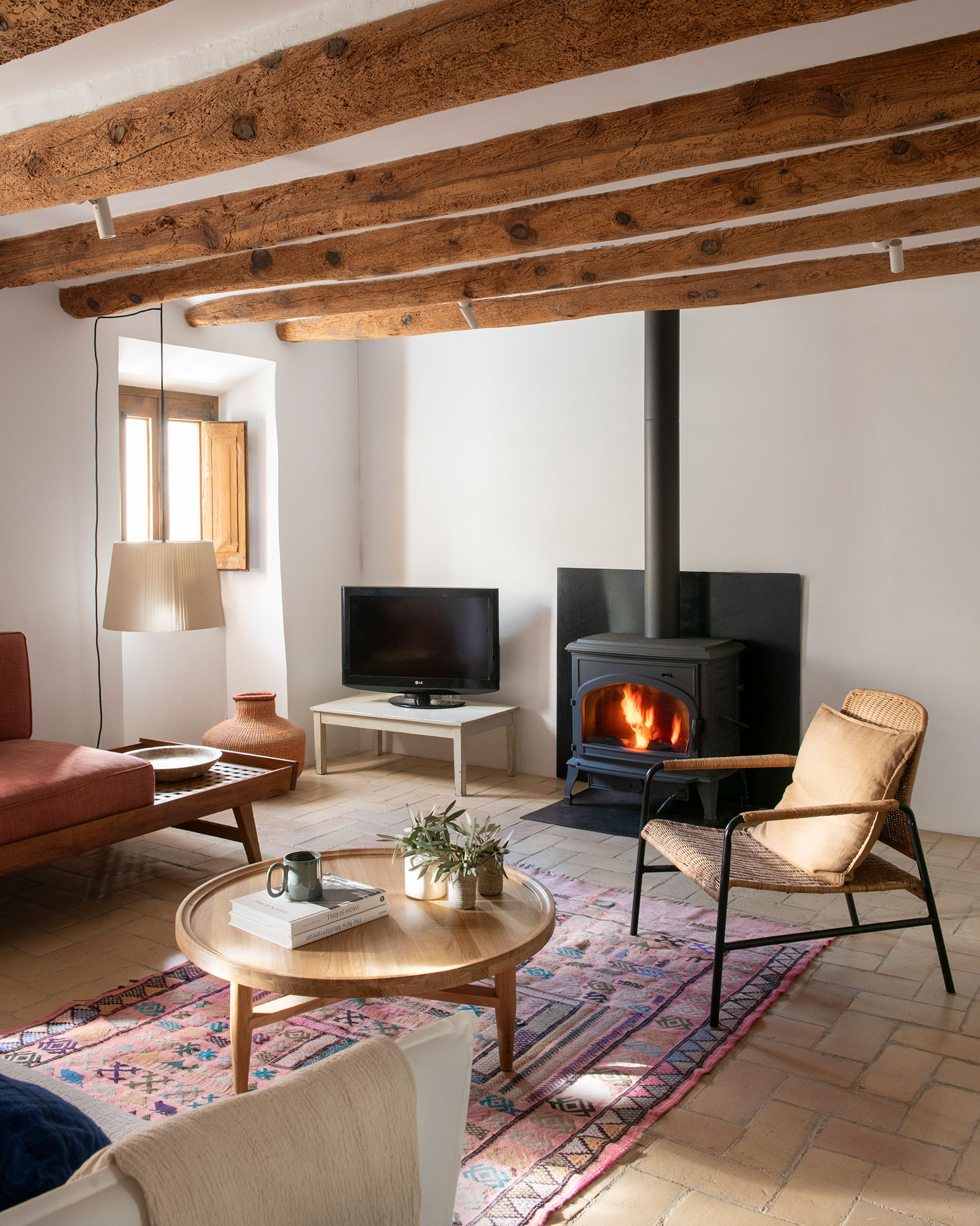 living room with beams and stove Catalan village house Casa Maltesa