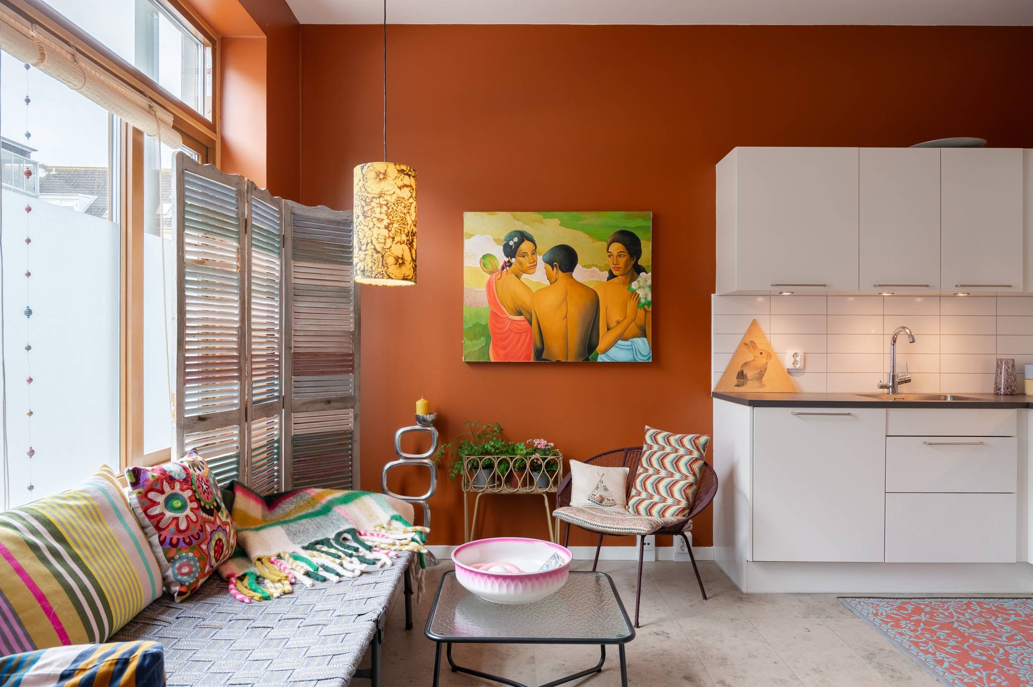 living room maximalist decor terracotta walls and white open kitchen