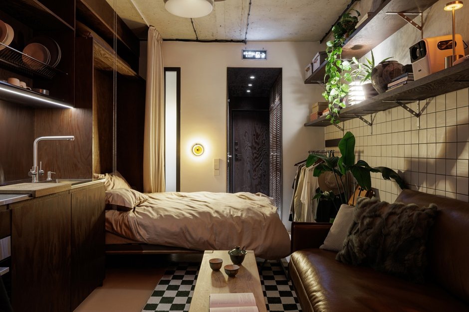 living room with fold-down bed hidden behind a curtain in a small studio living room with fold-down bed hidden behind a curtain in a small studio
