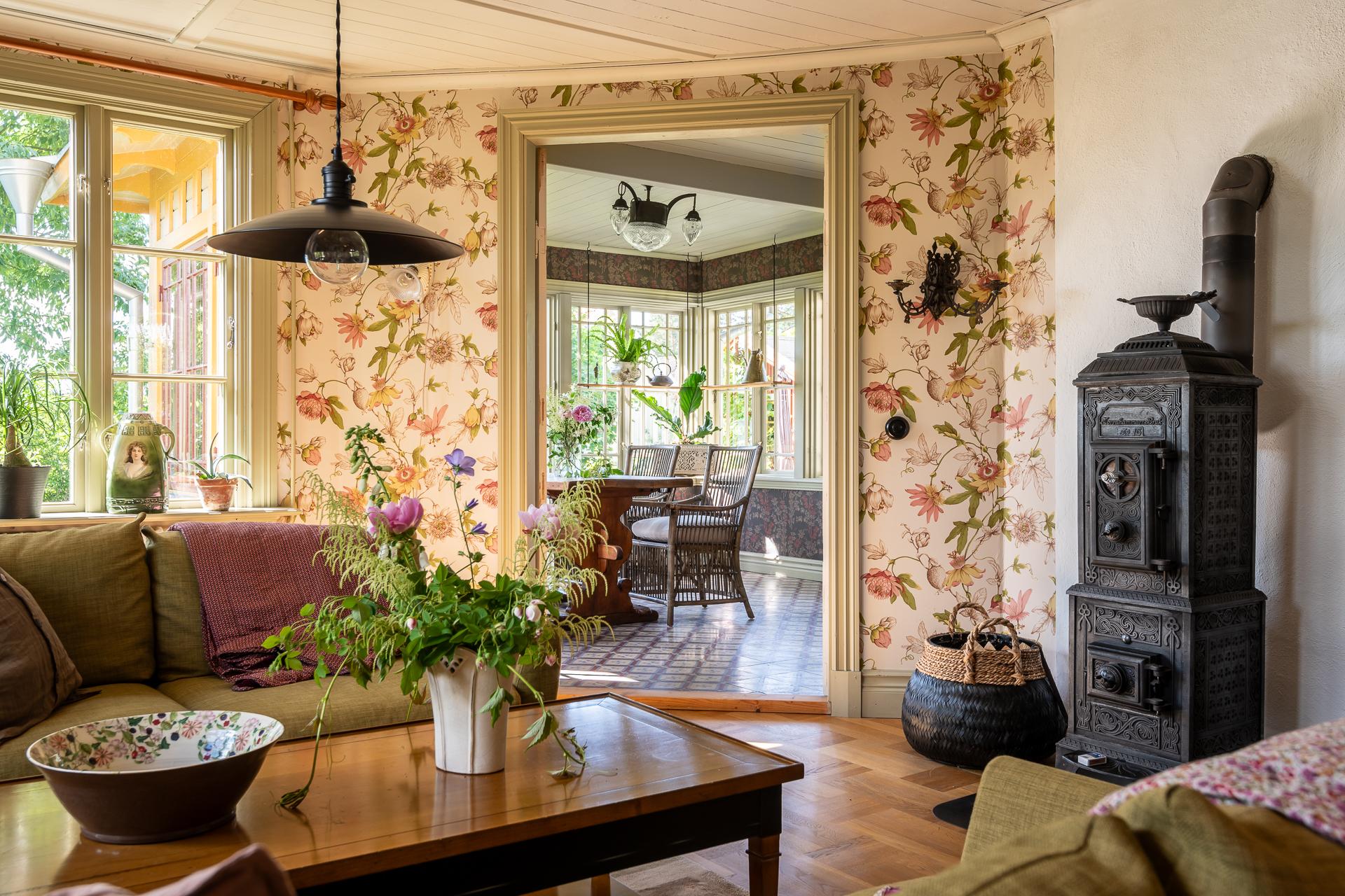 living room with floral wallpaper and old stove scandinavian decor