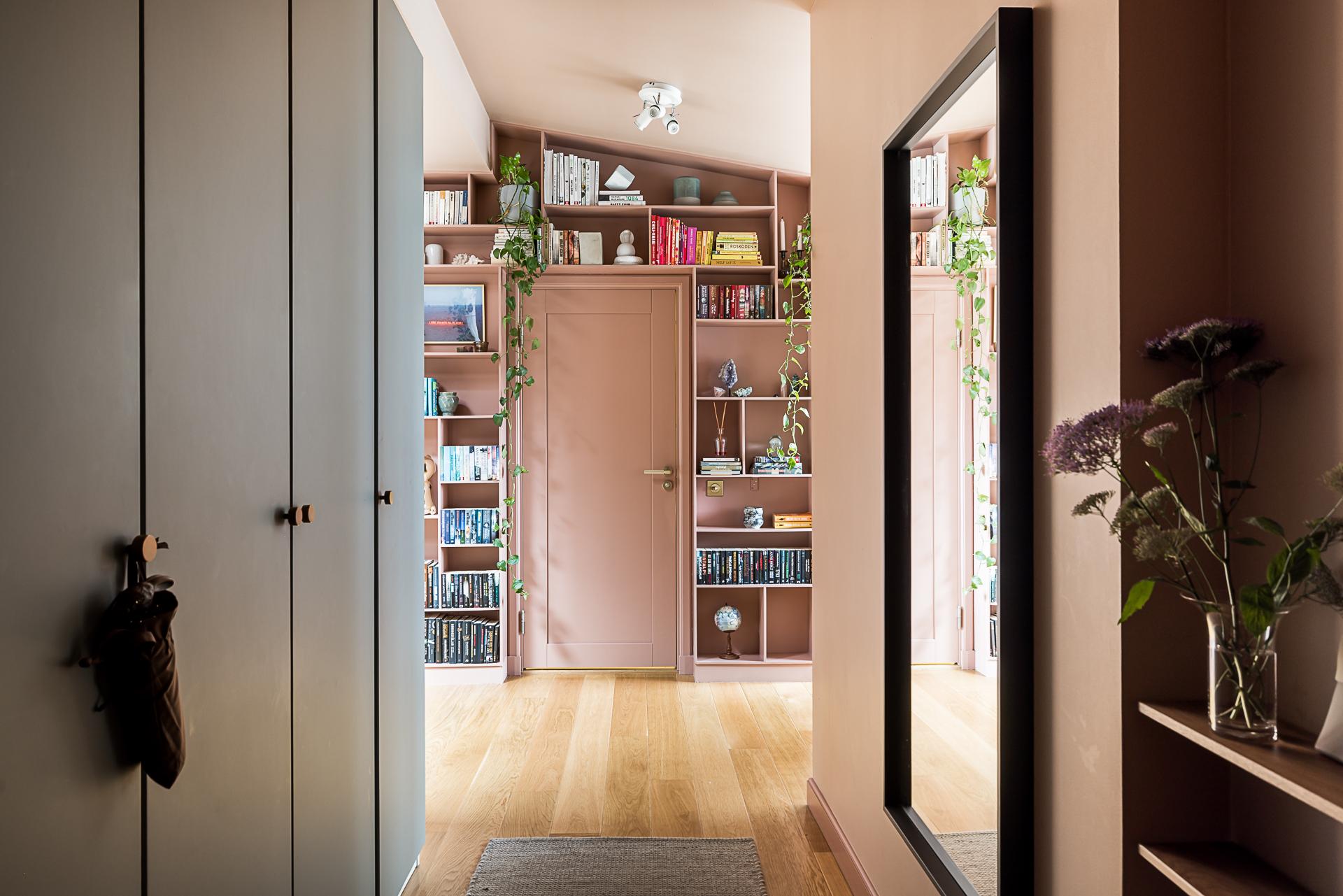 pink hallway with bookshelve