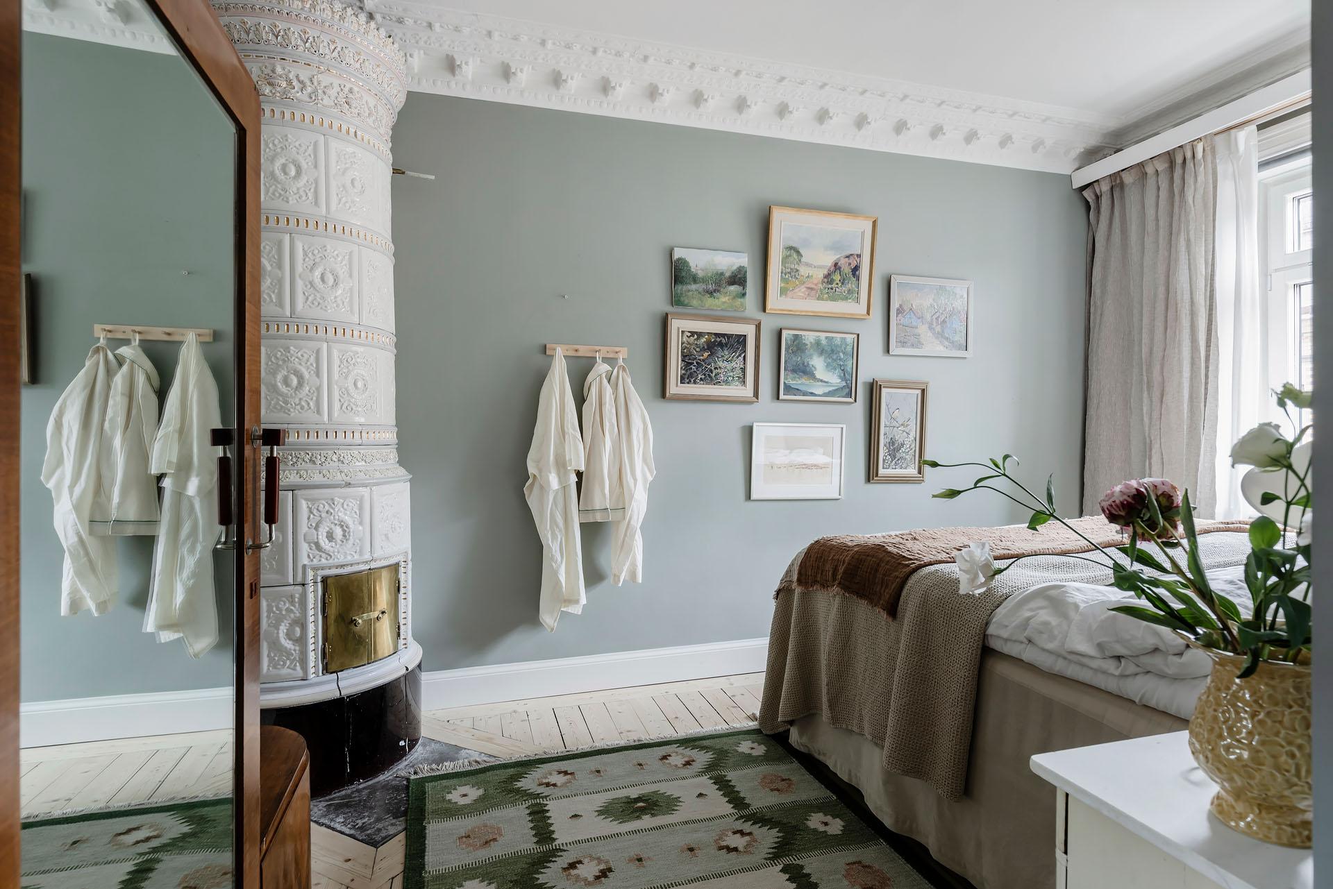 chambre murs bleu pâle avec moulures poêle en céramique blanche décoration scandinave appartement ancien 81m2