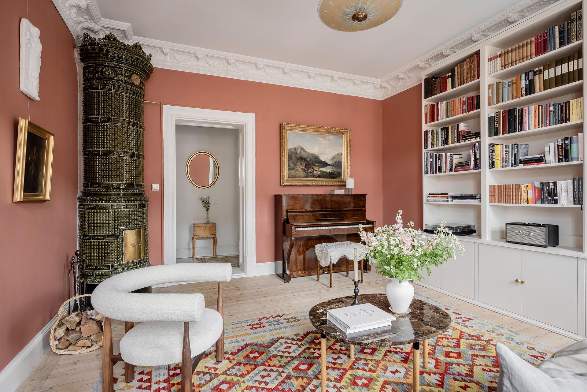salon avec moulures décoration scandinave murs terracotta poêle en céramique verte appartement ancien 81m2