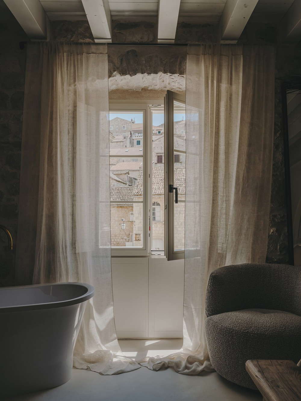 chambre avec poutres et murs de pierre baignoire design décoration contemporaine beige palais du 19e siècle Palazzo Caterina Hvar Croatie