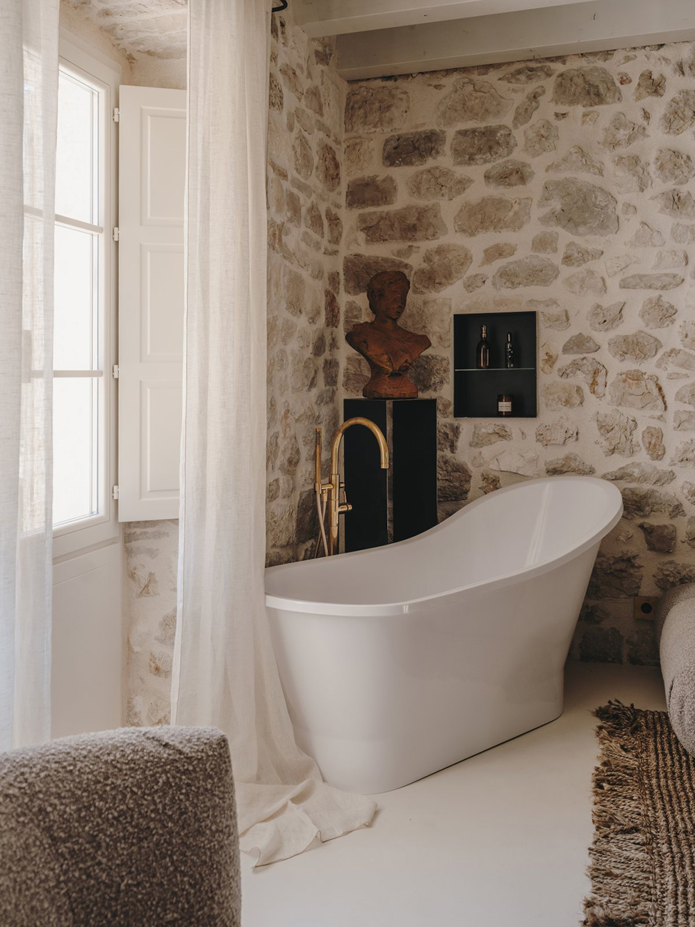chambre avec poutres et murs de pierre baignoire design décoration contemporaine beige palais du 19e siècle Palazzo Caterina Hvar Croatie