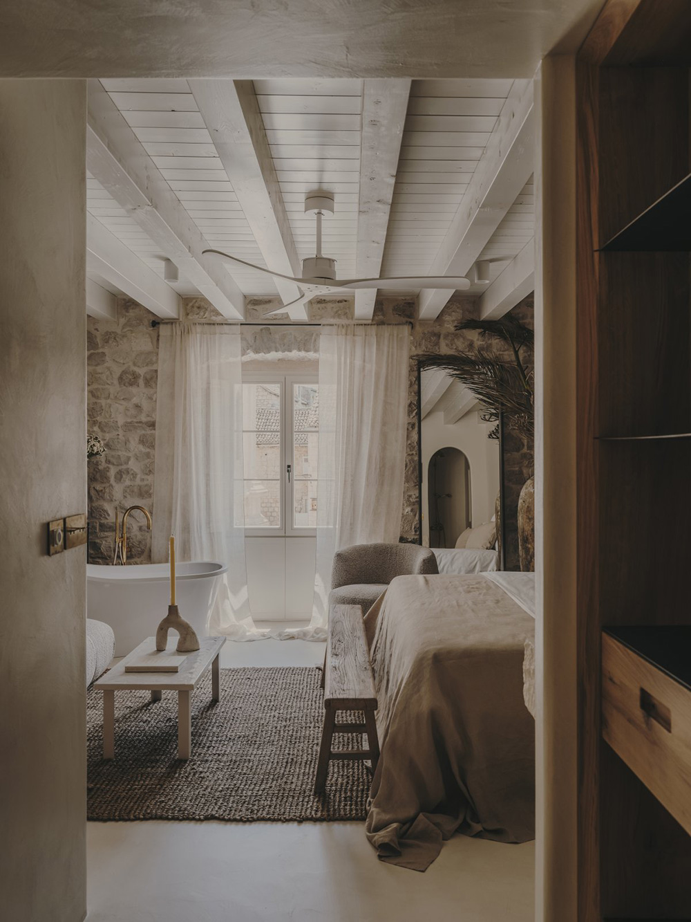 chambre avec poutres et murs de pierre baignoire design décoration contemporaine beige palais du 19e siècle Palazzo Caterina Hvar Croatie