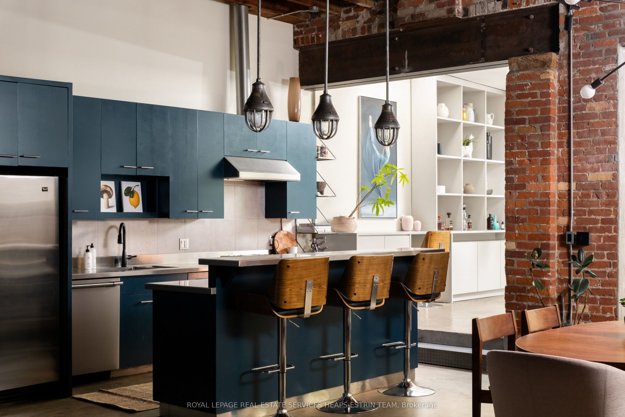 cuisine ouverte bleue design et salon avec poutres en acier et murs de briques loft authentique et ancien dans un ancien garage à Toronto cuisine ouverte bleue design et salon avec poutres en acier et murs de briques loft authentique et ancien dans un ancien garage à Toronto