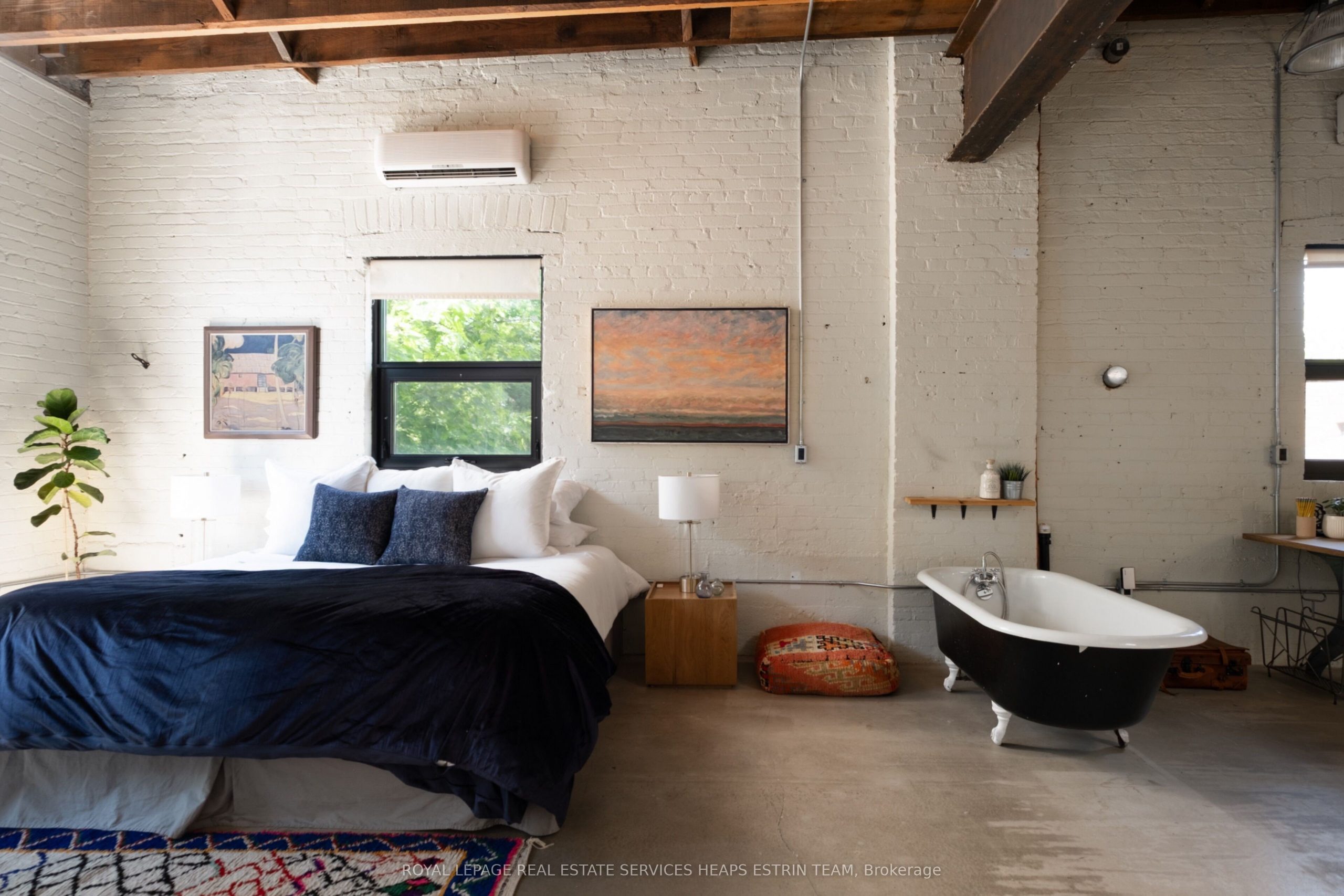 chambre avec baignoire avec poutres sol béton murs de briques blanches loft authentique et ancien dans un ancien garage à Toronto chambre avec baignoire avec poutres sol béton murs de briques blanches loft authentique et ancien dans un ancien garage à Toronto