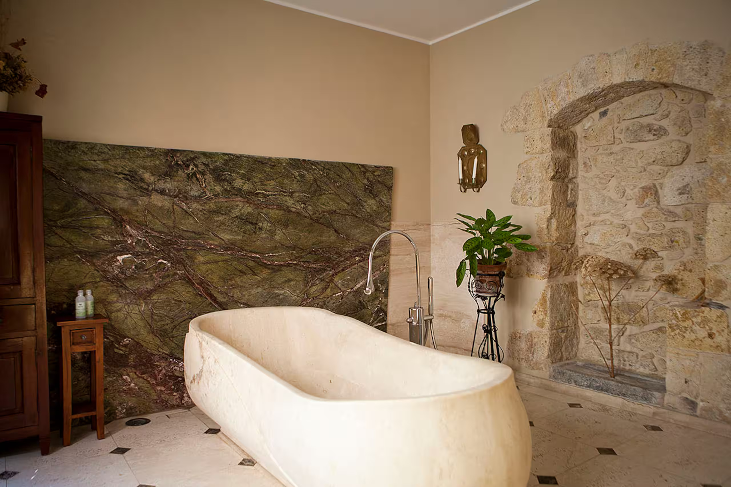 salle de bain mur de pierres baignoire en marbre maison de ville en Sardaigne