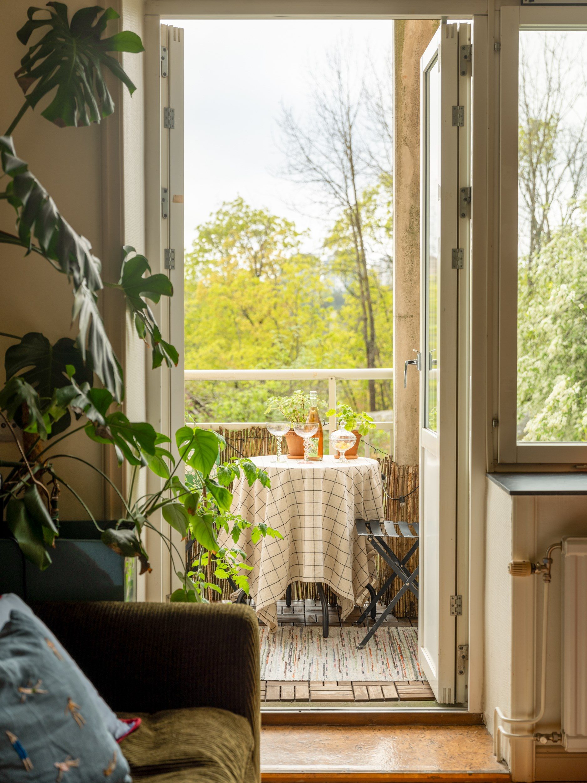 balcon et salon avec canapé vert décoration vintage et scandinave deux-pièces 42m2 